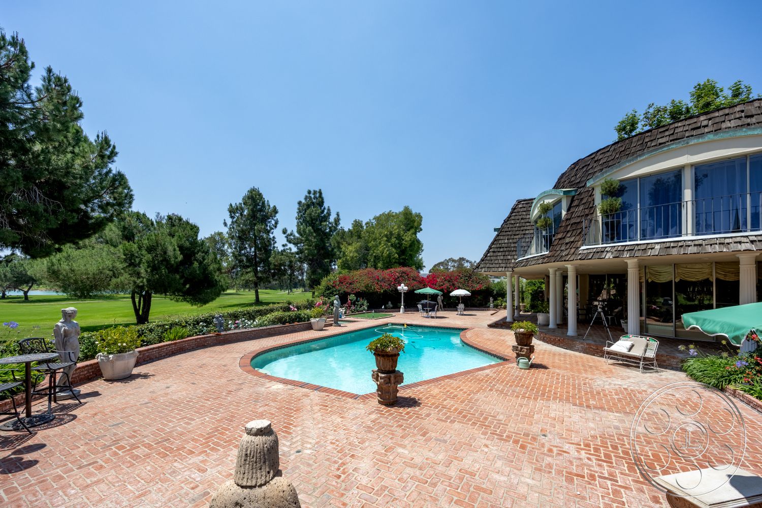 Euphoria - exterior, landscaped garden, large glass windows, outdoor seating area, rectangular pool, stone planters, shingle roof, brick patio flooring, green lawn setting, wooden deck chairs, poolside deck, ornamental garden statues