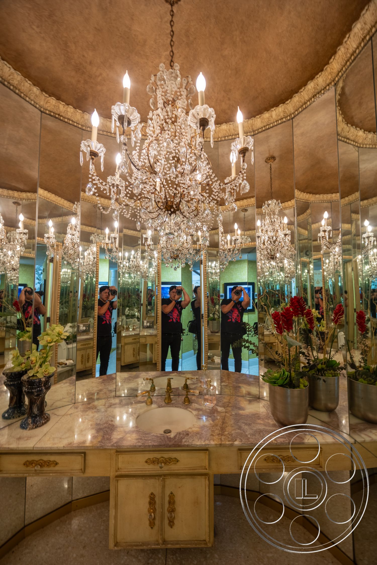 Euphoria - gold accents, luxurious finishes, chandelier lighting, marble countertop, decorative planters, mirrored wall, modern bathrooms, traditional cabinetry, ornate ceiling detail
