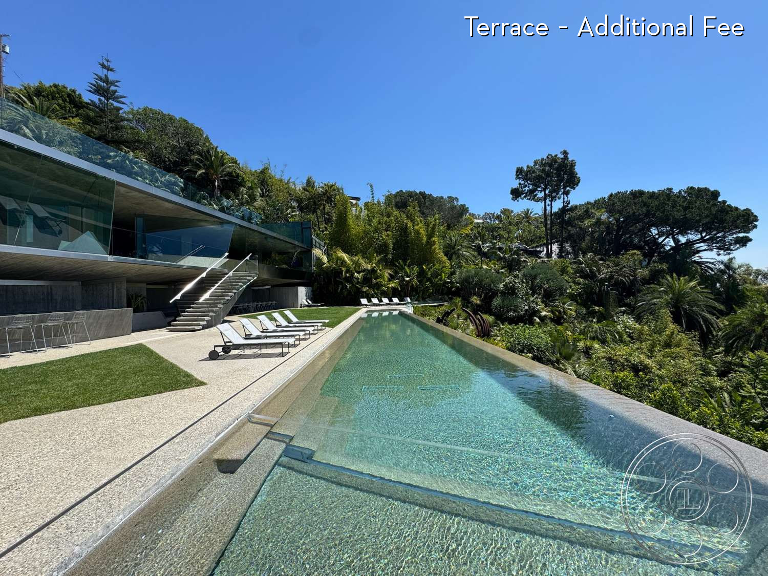 Goldstein House - infinity pool, wood deck, glass railing, exterior, landscaped garden, tropical setting, minimalistic design, exposed concrete walls, modern architectural style, grassy lawn, sloping hillside, metal outdoor furniture, concrete pool border, concrete patio floor, floor-to-ceiling glass
