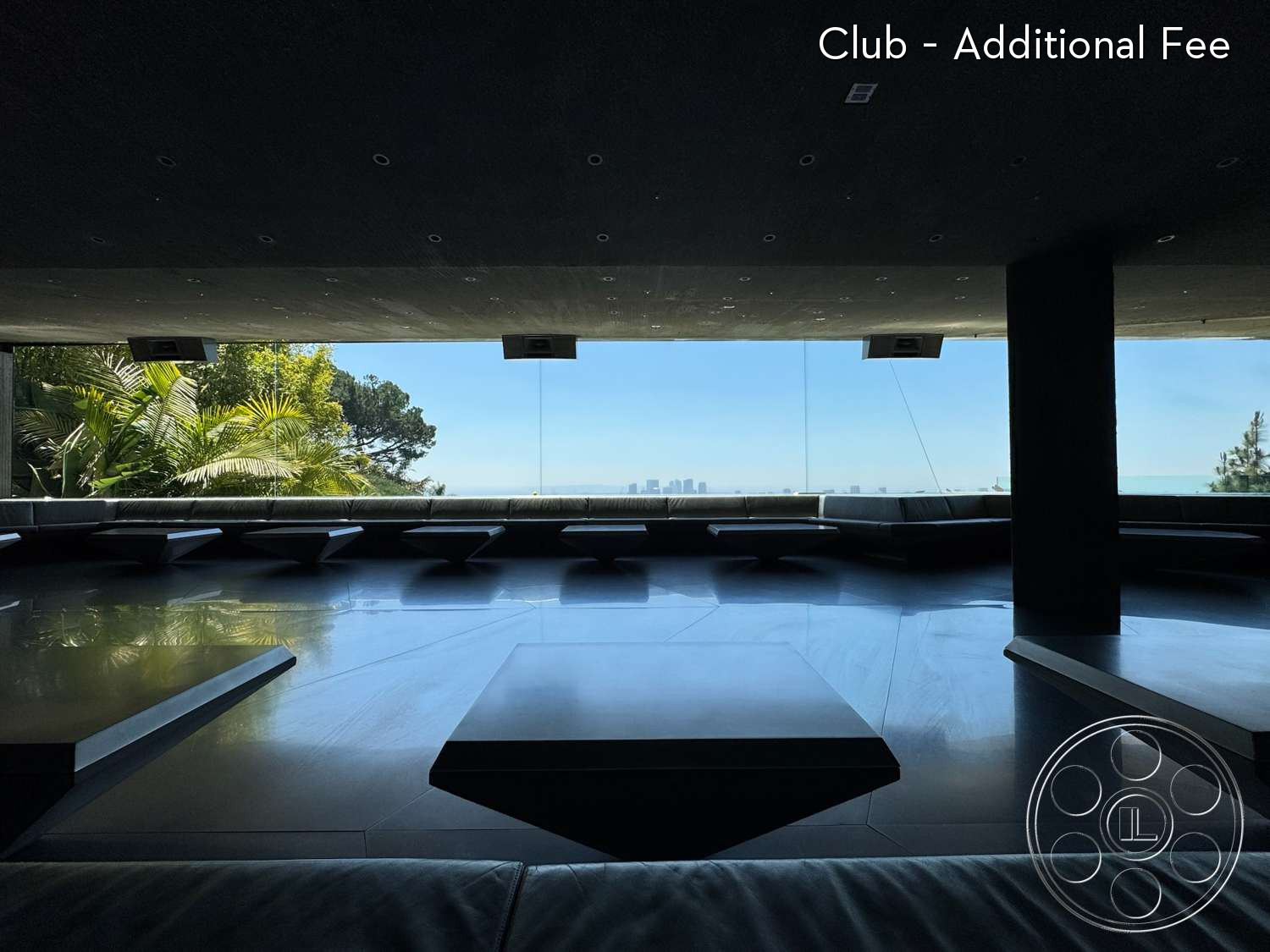 Goldstein House - indoor-outdoor flow, open living space, polished concrete floors, modern minimalist design, floor-to-ceiling glass windows, surrounded by greenery, panoramic city skyline view, rectangular seating area, dark wood supports, extensive natural light