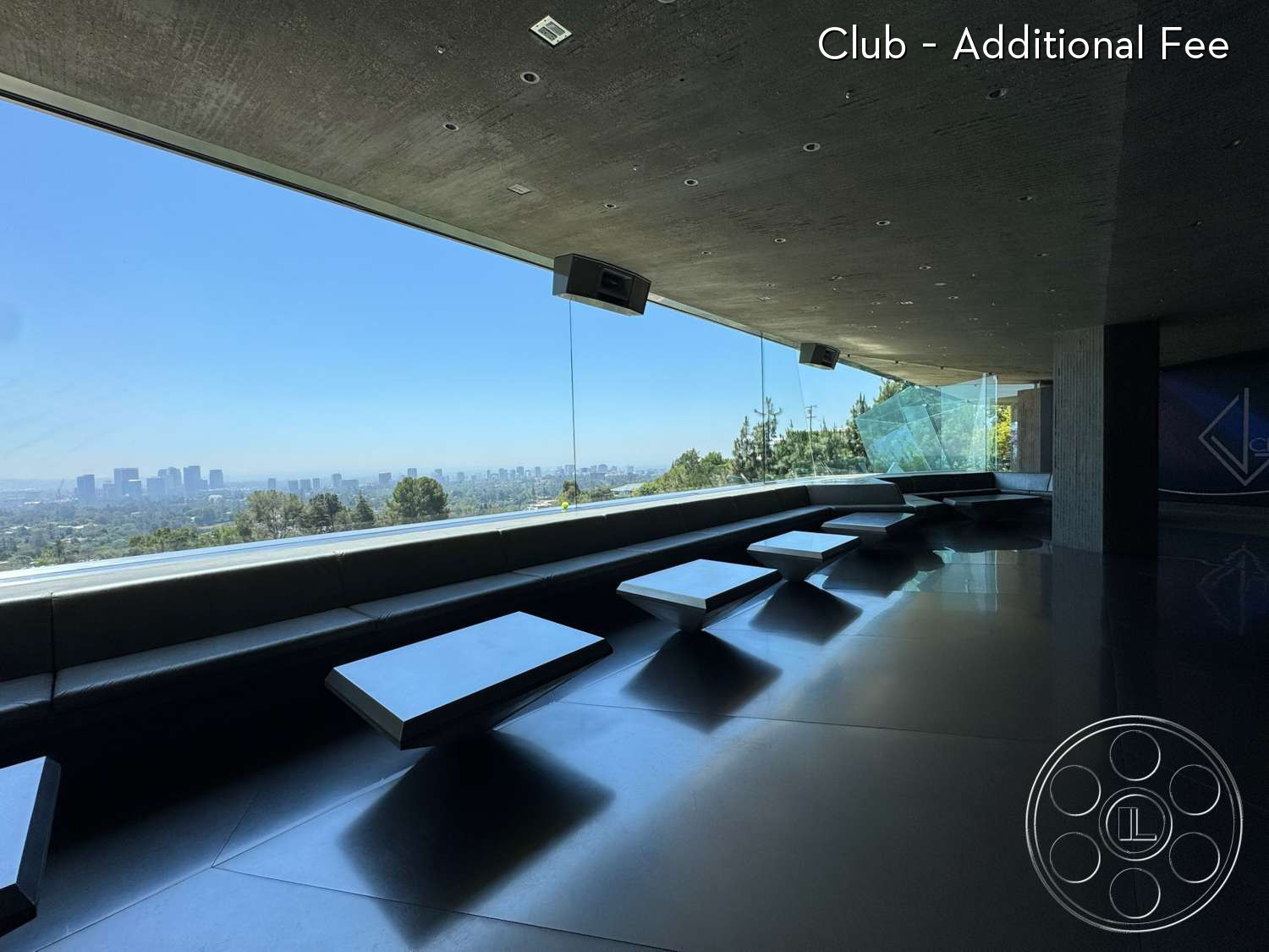 Goldstein House - concrete ceiling, minimalist design, contemporary style, open concept layout, floor-to-ceiling glass windows, black tile flooring, panoramic city skyline view, curved seating area, slanted glass walls