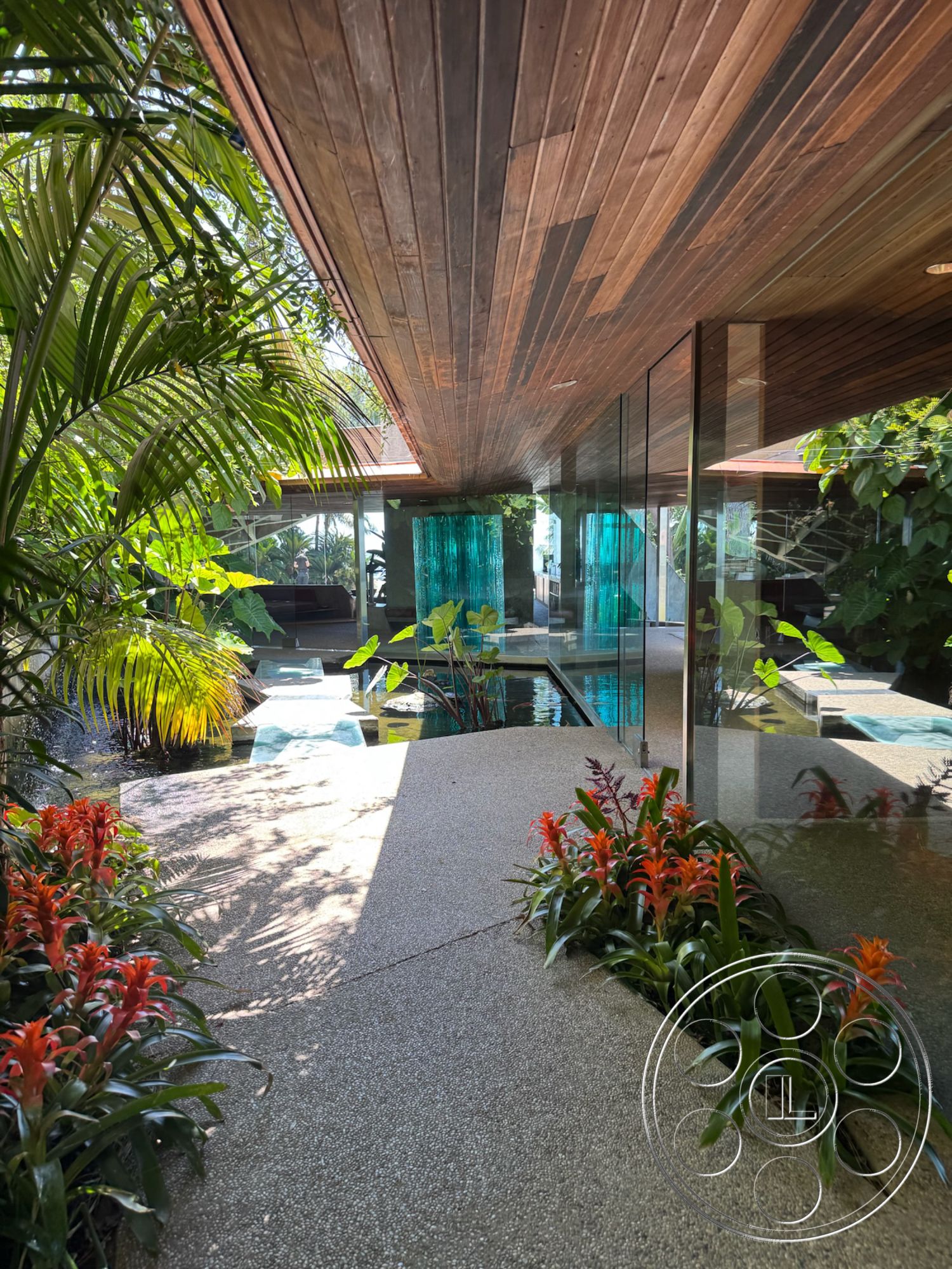 Goldstein House - exterior, modern design elements, ambient lighting, water feature, contemporary architecture, outdoor living space, tropical landscaping, raised garden beds, open-air layout, glass wall panels, potted tropical plants, luxury pool area, wood ceiling boards, pebble aggregate flooring, slate stone pathways
