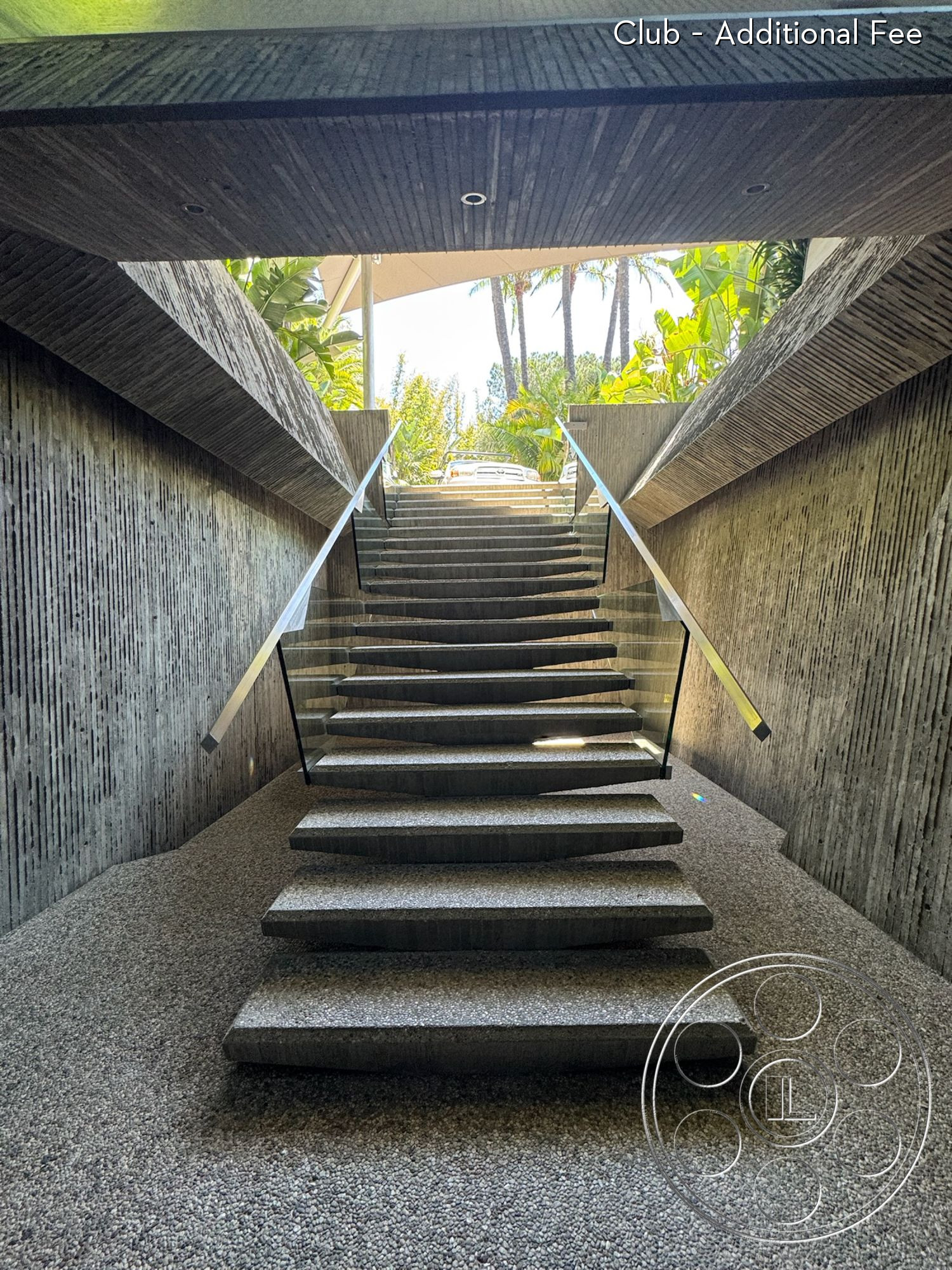 Goldstein House - exterior, glass railings, textured concrete walls, modern architectural design, gravel flooring, natural light entry, polished concrete steps, textured concrete staircase, vertical concrete groove details, landscape viewing area with tropical plants