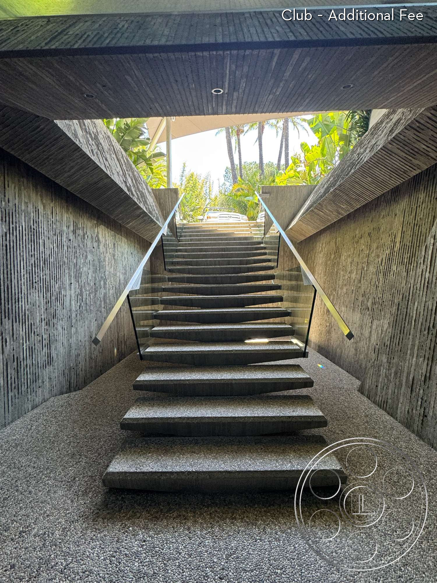 Goldstein House - exterior, glass railings, textured concrete walls, modern architectural design, gravel flooring, natural light entry, polished concrete steps, textured concrete staircase, vertical concrete groove details, landscape viewing area with tropical plants