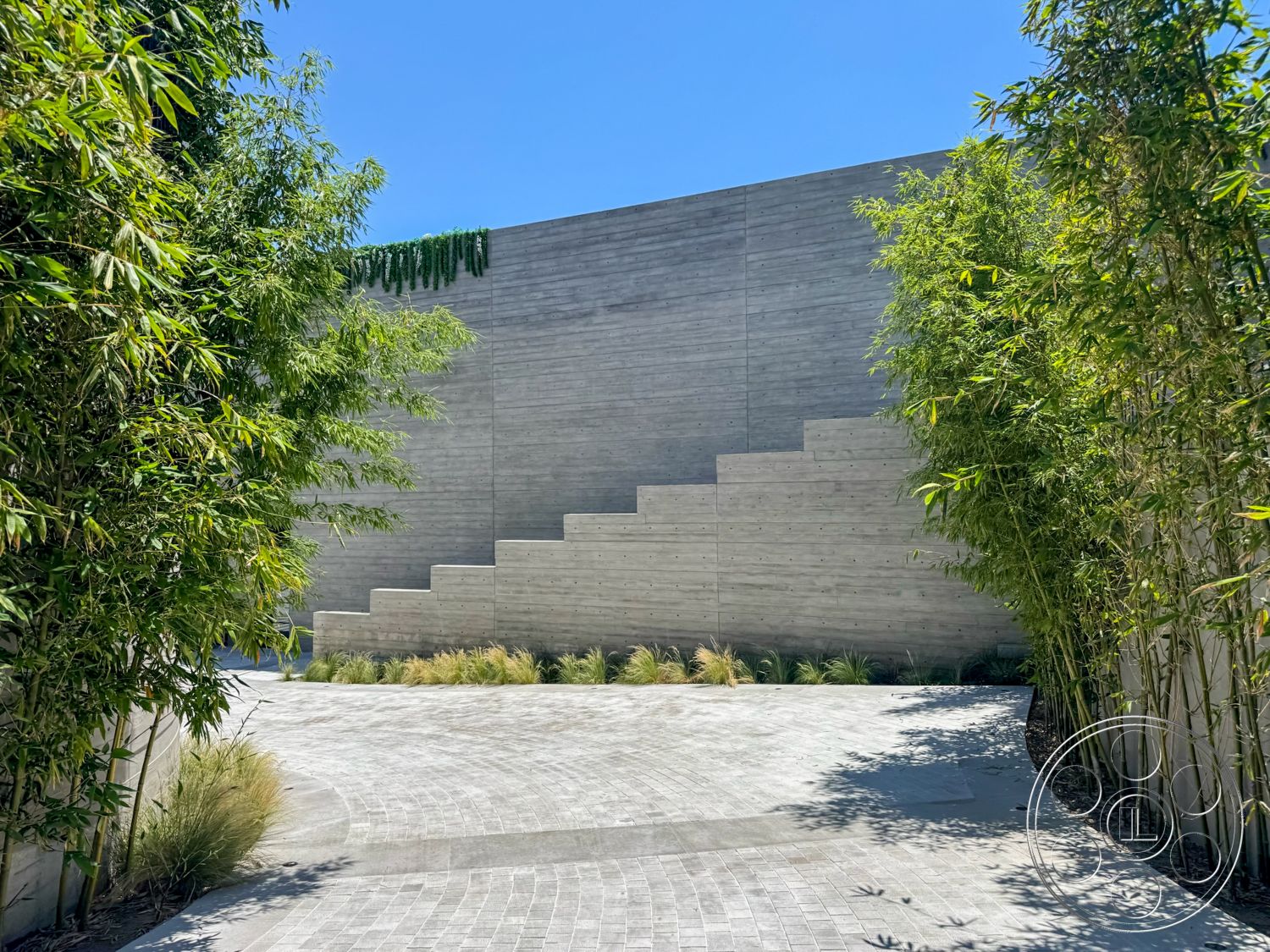 Star Villa - exterior, paved driveway, concrete wall, modern architectural style, curved driveway, textured concrete surface, bamboo landscaping, step-like concrete feature, step terraces, grass accents