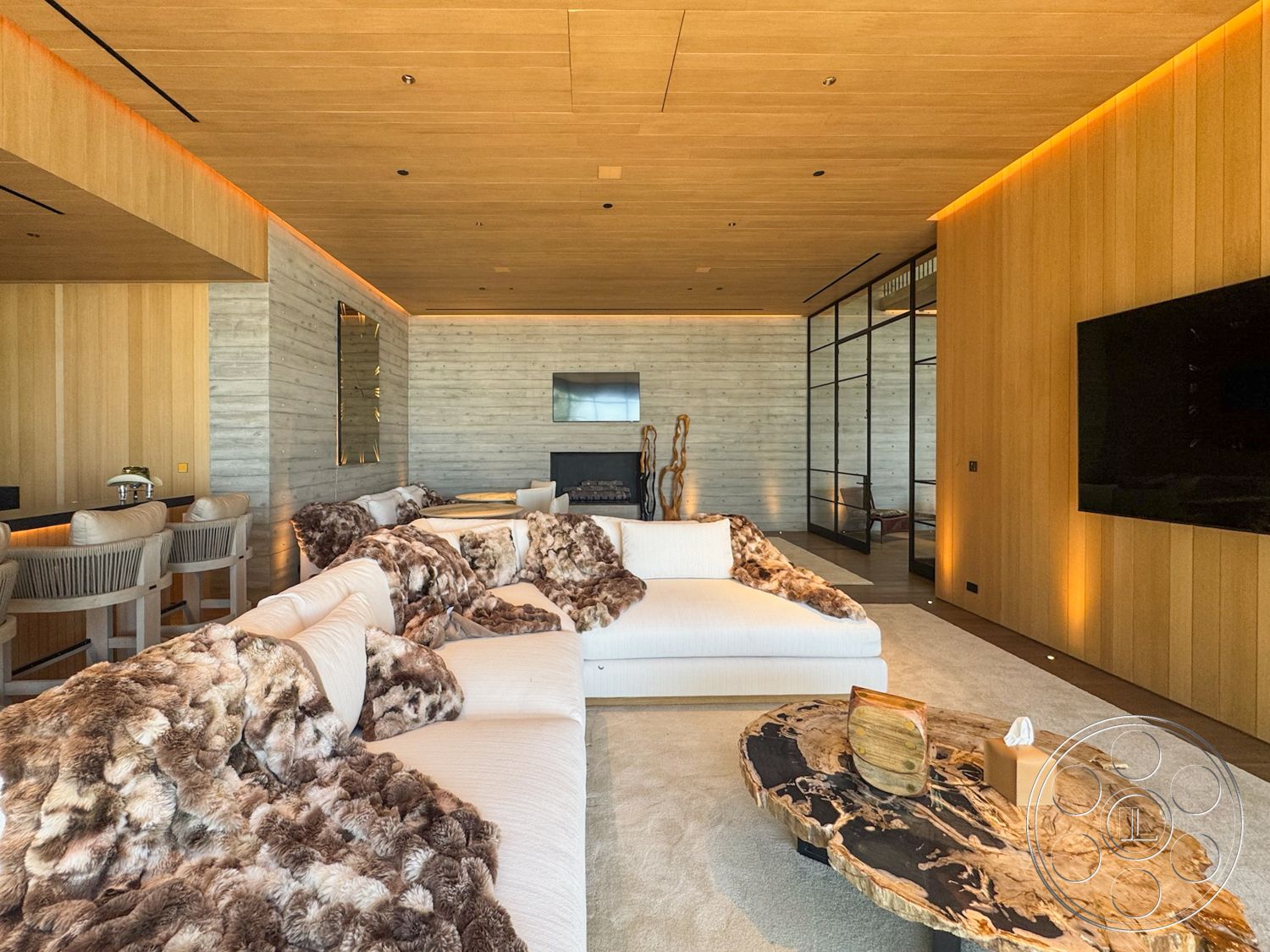 Star Villa - bar seating area, floor-to-ceiling windows, open concept living space, minimalist decor style, modern recessed lighting, natural light filled room, wood paneling walls, exposed concrete feature wall, soft textured carpet flooring, custom sectional sofa with fur throws, live edge wood coffee table, textural wall art