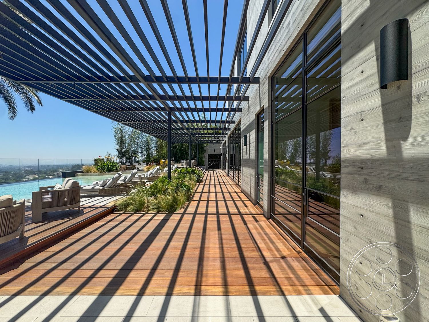 Star Villa - exterior, modern outdoor furniture, concrete walls, horizontal wooden slats, contemporary architectural style, wooden deck flooring, sunlit outdoor area, metal pergola structure, pool area with lounge chairs, landscaped garden elements, glass railing pool enclosure, views of surrounding landscape