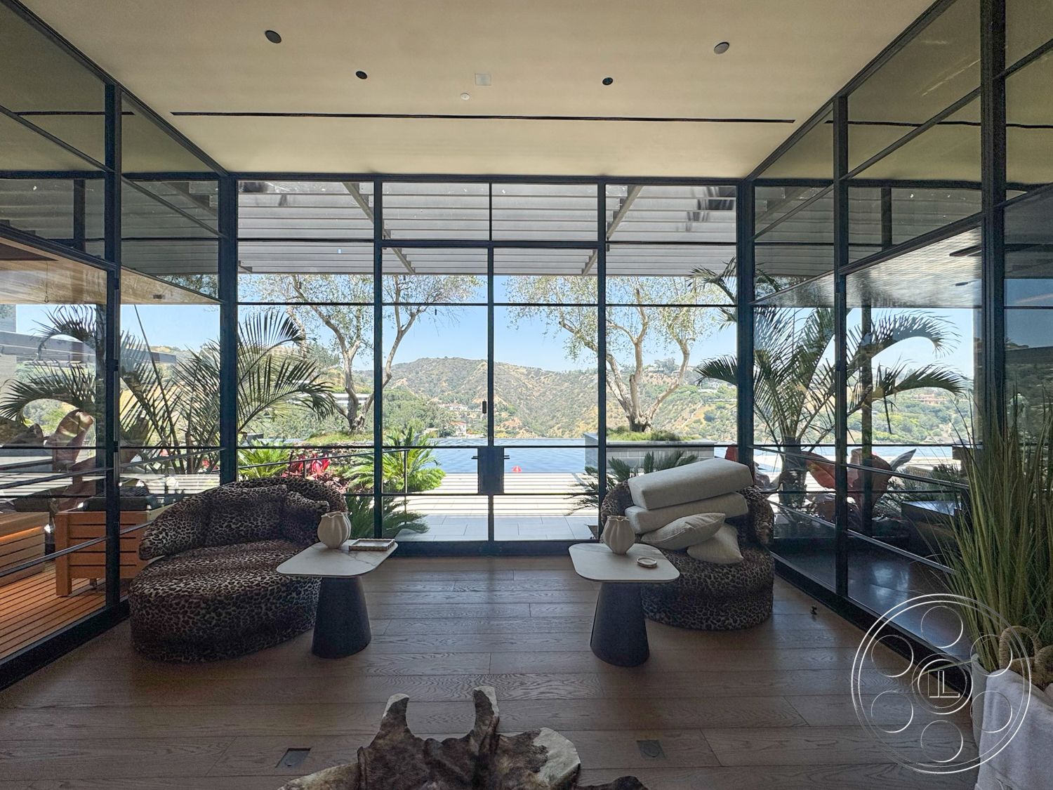 Star Villa - natural light, minimalist design, contemporary furniture, light hardwood flooring, decorative plants, open space layout, mountain view, wood beam ceiling, glass wall panels, modern coffee tables, lakefront property, dark metal framing, leopard print upholstery