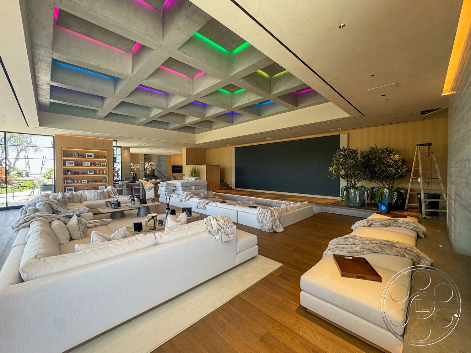 Star Villa - neutral color palette, light hardwood flooring, textured wall treatment, decorative potted plants, floor-to-ceiling glass windows, built-in wooden shelving, LED accent lighting, spacious living room layout, modern sectional sofas, minimalist coffee tables, concrete coffered ceiling