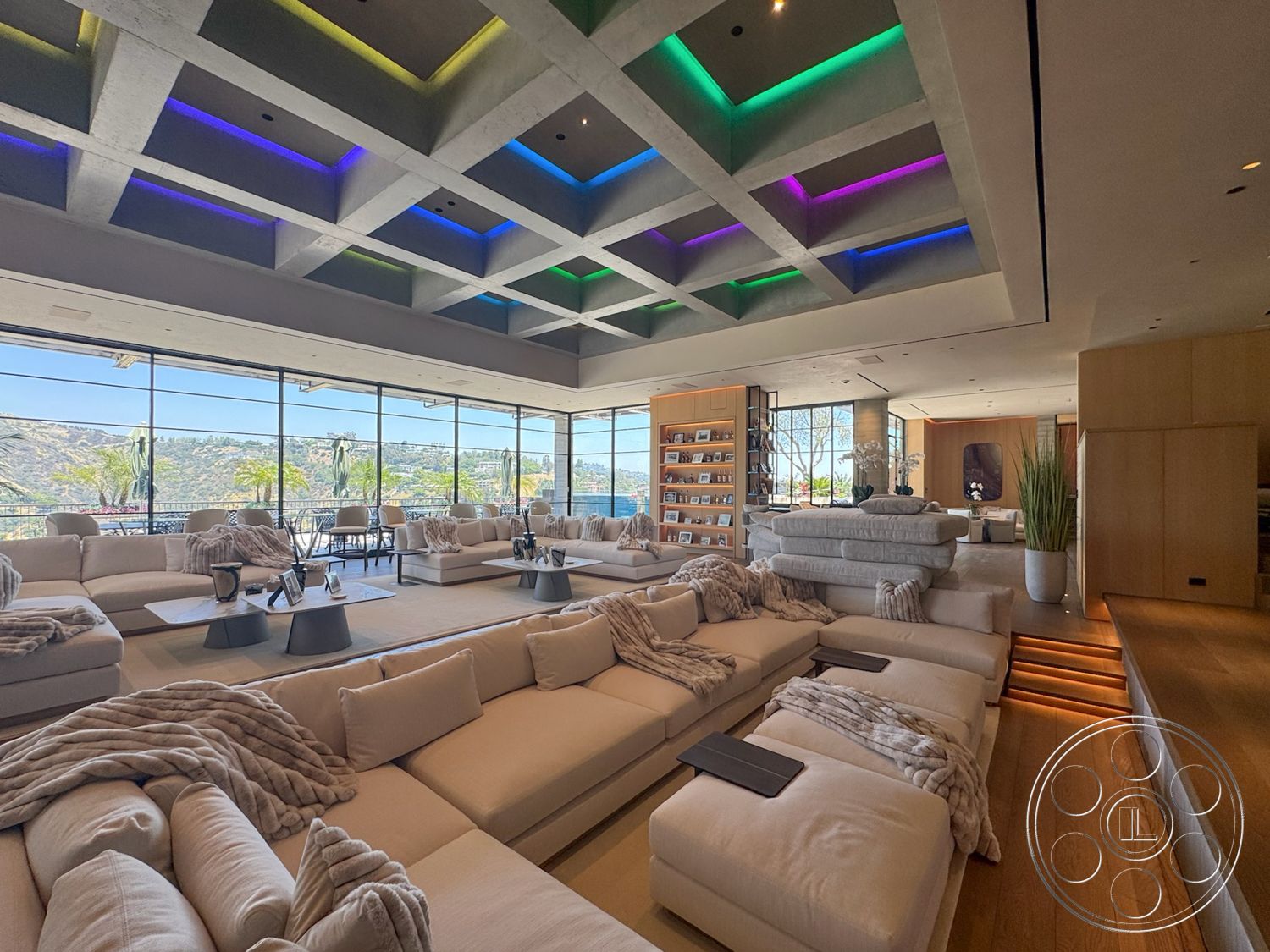 Star Villa - hardwood flooring, recessed lighting, glass coffee table, elegant decor elements, wooden shelving units, contemporary architectural style, modern sectional sofa, floor-to-ceiling glass windows, wood panel accent wall, suburban hillside location, concrete coffered ceiling, neutral-colored throw blankets, open spacious layout