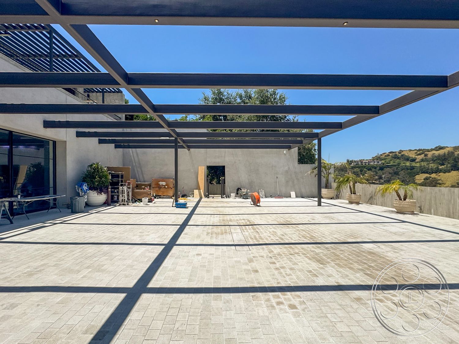 Star Villa - exterior, outdoor landscaping, floor-to-ceiling windows, modern architectural style, smooth concrete walls, sunlit outdoor space, steel pergola structure, suburban hillside location, concrete paver patio flooring
