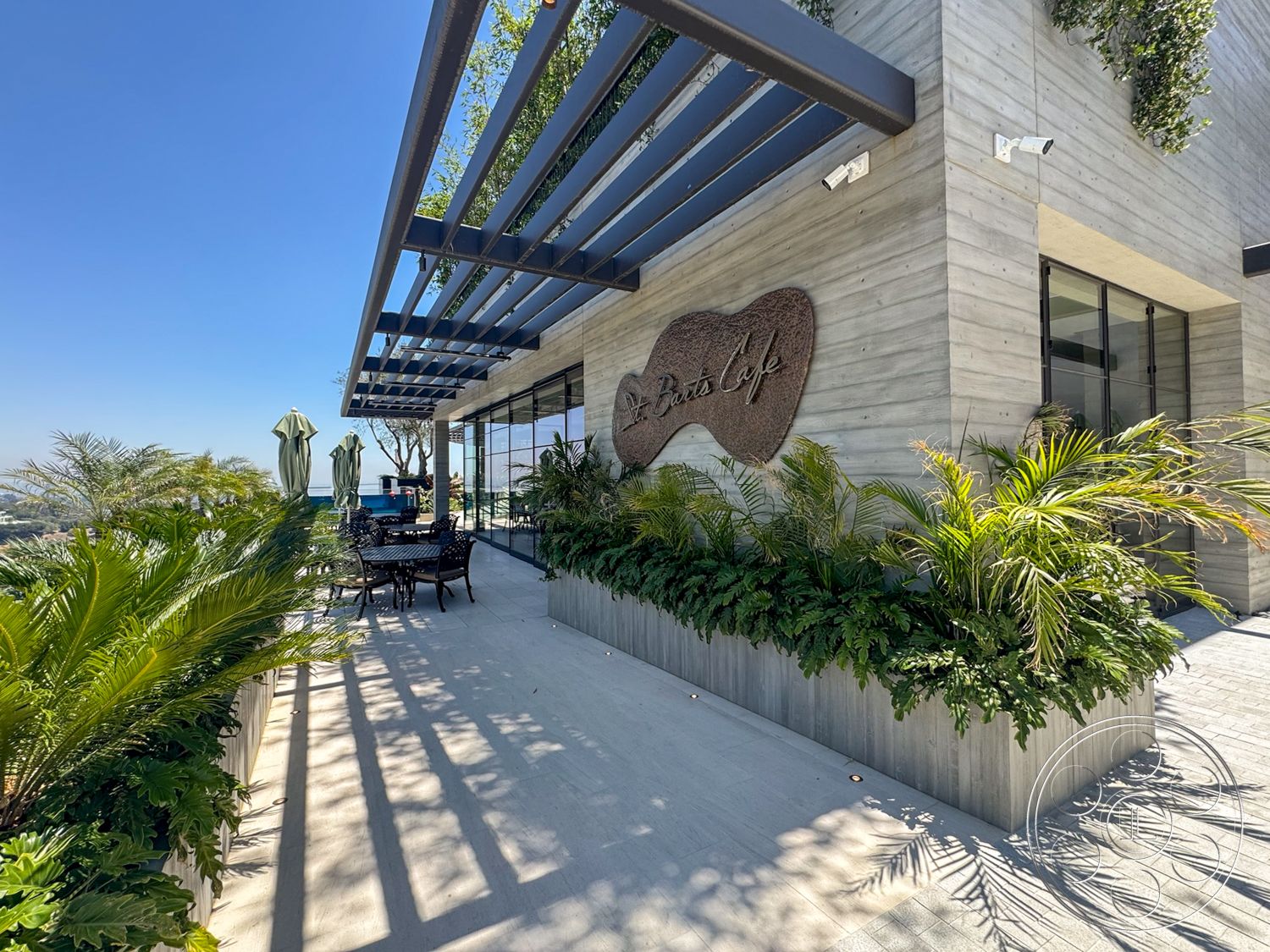 Star Villa - exterior, landscaped greenery, modern architectural style, concrete wall finish, patio dining area, glass floor-to-ceiling windows, wood planter box, steel pergola, outdoor table and chairs, tropical flora