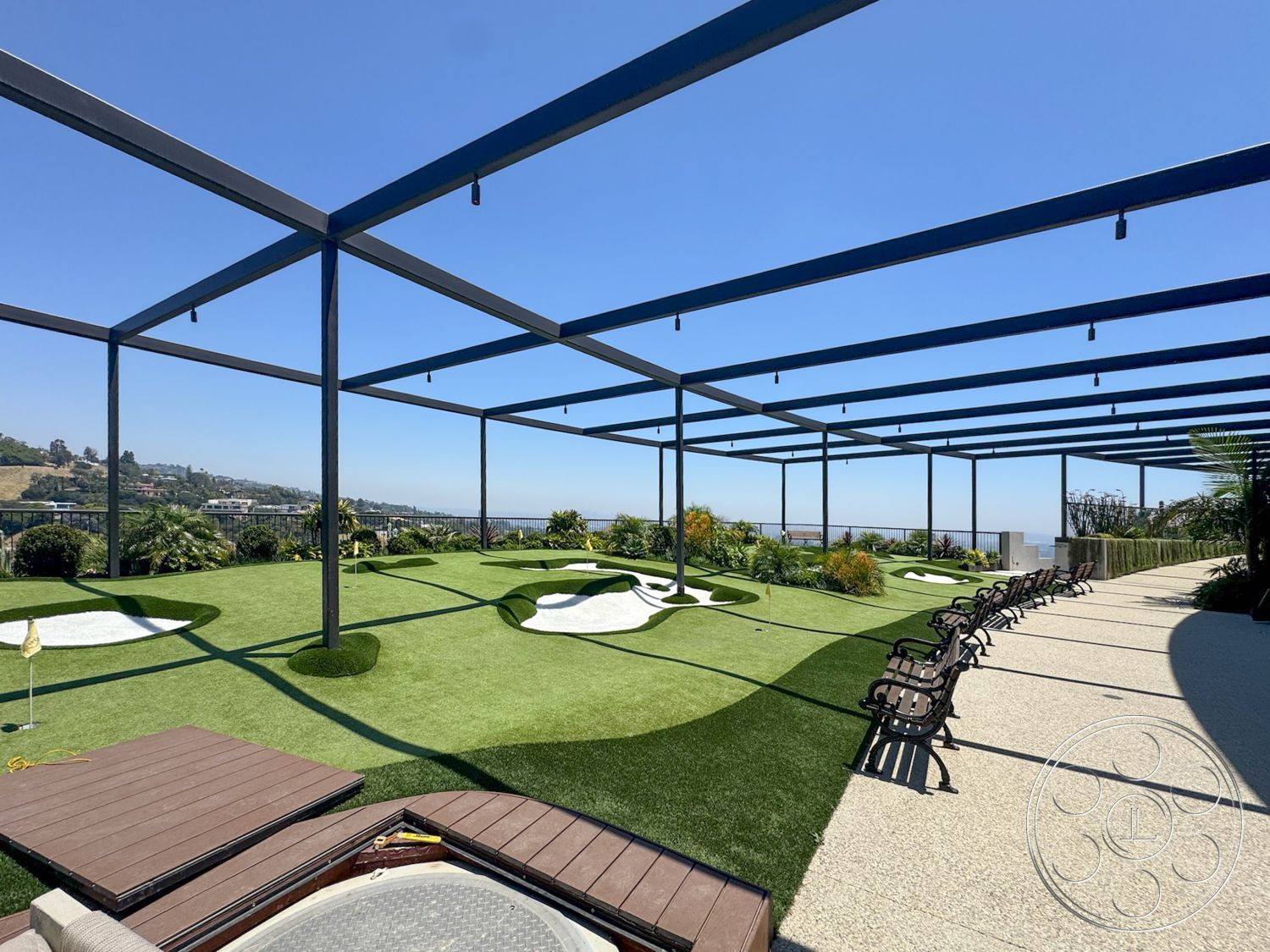 Star Villa - exterior, outdoor seating area, suspended lighting fixtures, scenic hillside view, concrete patio flooring, landscaped garden beds, wooden deck area, artificial grass lawn, metal framework structure, golf putting green with contours