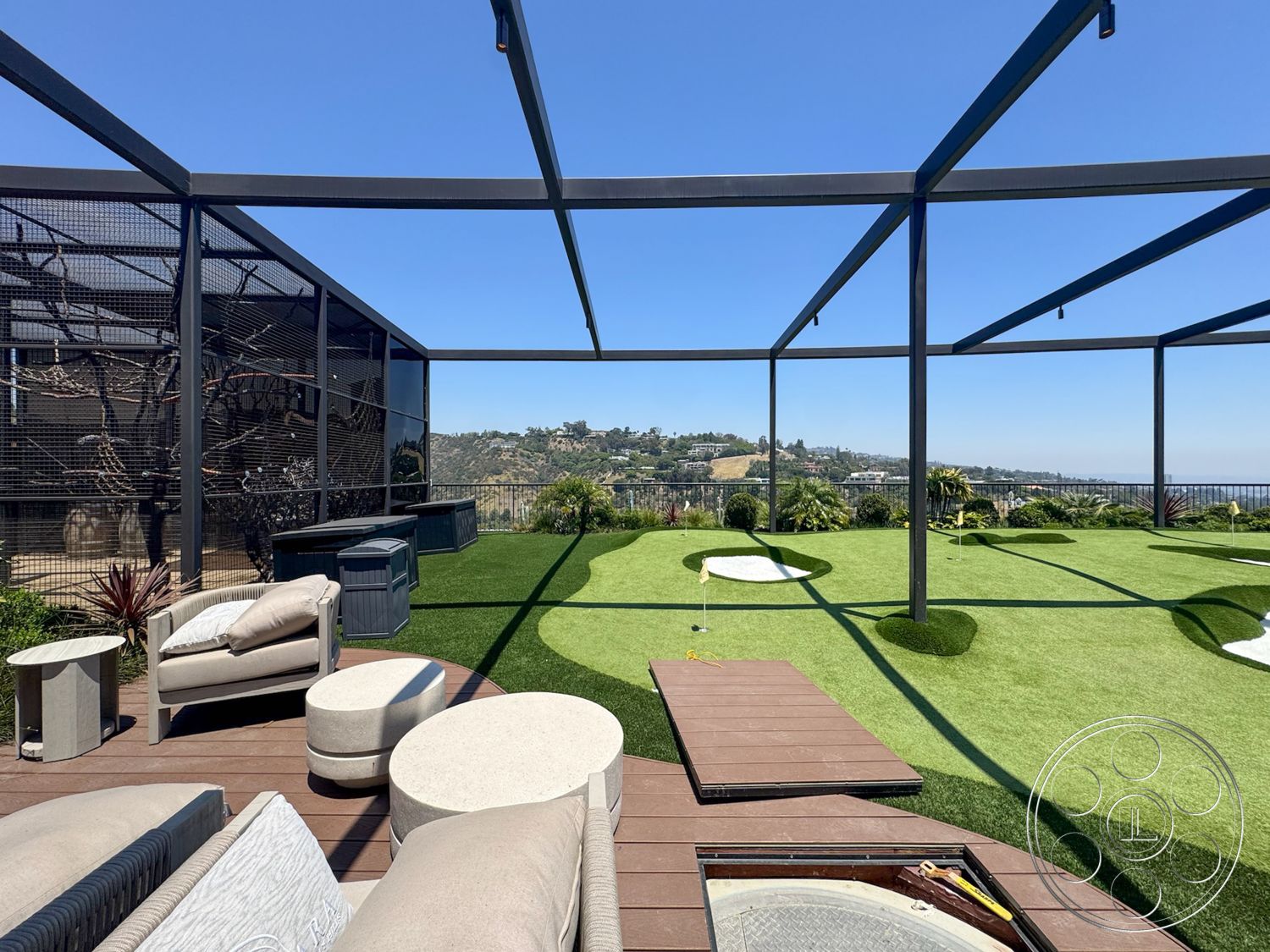 Star Villa - exterior, glass railing, scenic hillside view, golf putting green, minimalist outdoor design, artificial grass lawn, metal pergola structure, upholstered outdoor sofa, composite decking patio, concrete outdoor table, solid wood side tables