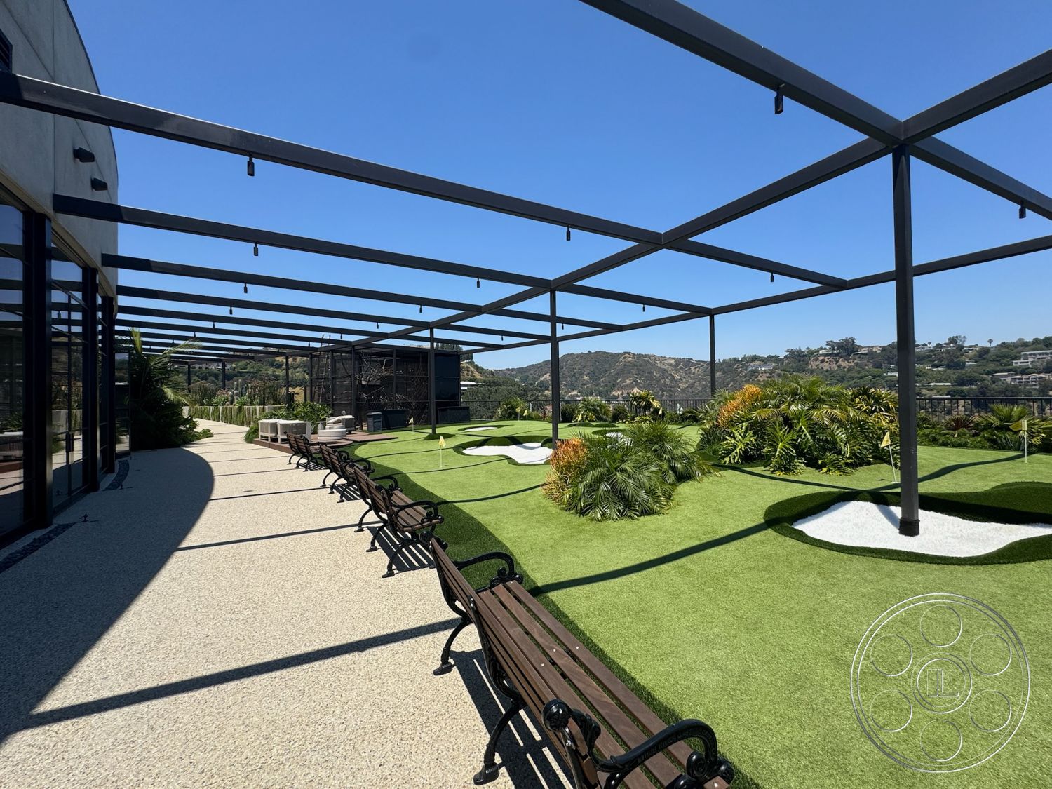Star Villa - exterior, outdoor seating area, landscaped greenery, contemporary architecture, open-air design, view of hillside, concrete patio flooring, synthetic grass lawn, metal pergola framework, defined putting greens