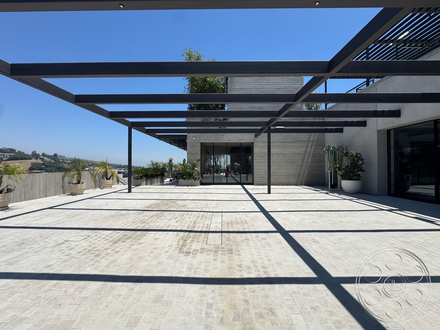 Star Villa - exterior, large glass sliding doors, concrete planters, modern architectural style, open outdoor space, hillside location, horizontal wood siding, concrete terrace flooring, steel pergola structure, potted palm plants