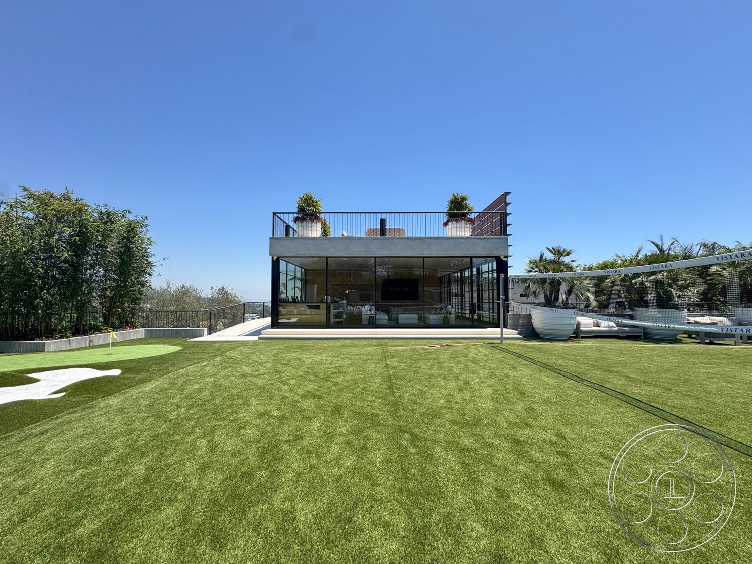 Star Villa - exterior, flat roof, glass sliding doors, exposed concrete walls, metal railing, potted greenery, modern architectural style, outdoor entertainment area, concrete patio area, landscaped grass lawn, city skyline backdrop, pergola structure, vacation home setting