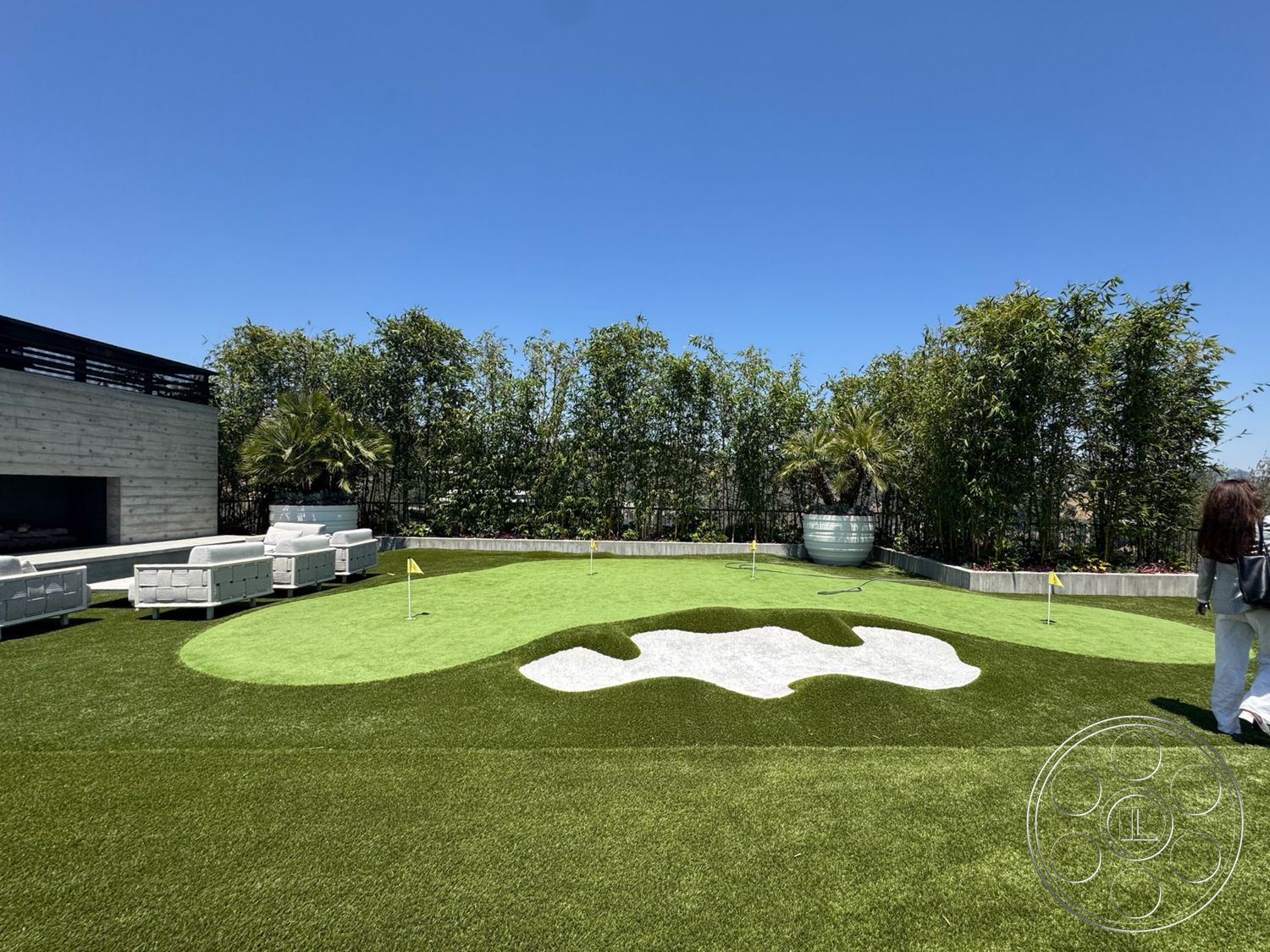 Star Villa - exterior, modern outdoor furniture, concrete planters, concrete seating area, landscaped garden setting, wooden deck area, open sky view, synthetic grass putting green, tall bamboo privacy screen, designed landscape with golf elements