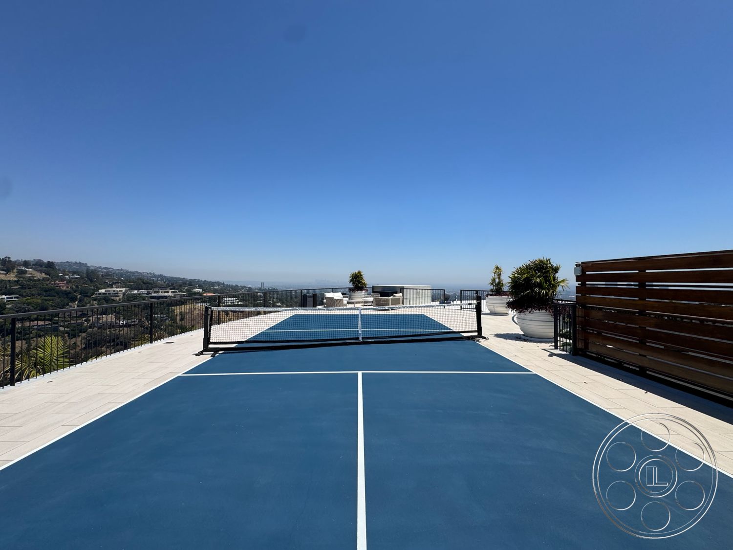 Star Villa - exterior, clear blue sky, mountain view setting, concrete patio flooring, planter pots with greenery, blue tennis court surface, metal railing fencing