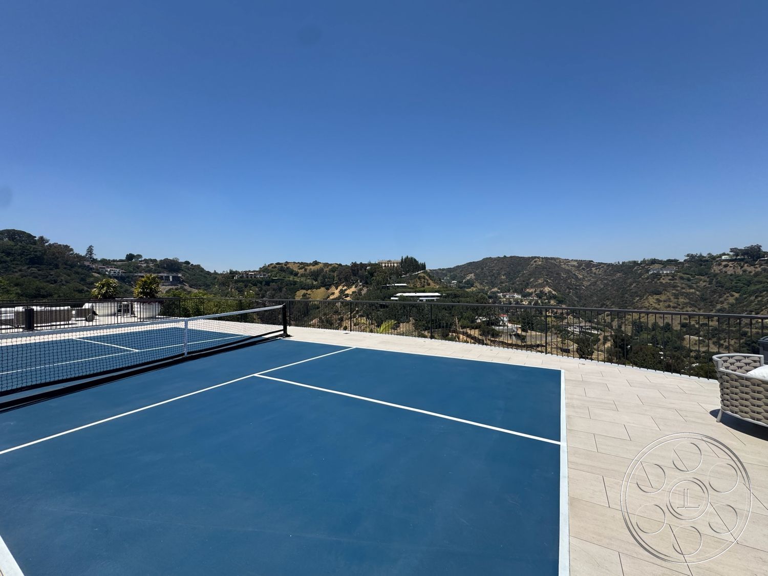 Star Villa - exterior, clear blue sky, mountain view setting, stone tile patio flooring, blue sports court surface, white netting for tennis, metal railing surrounding the court
