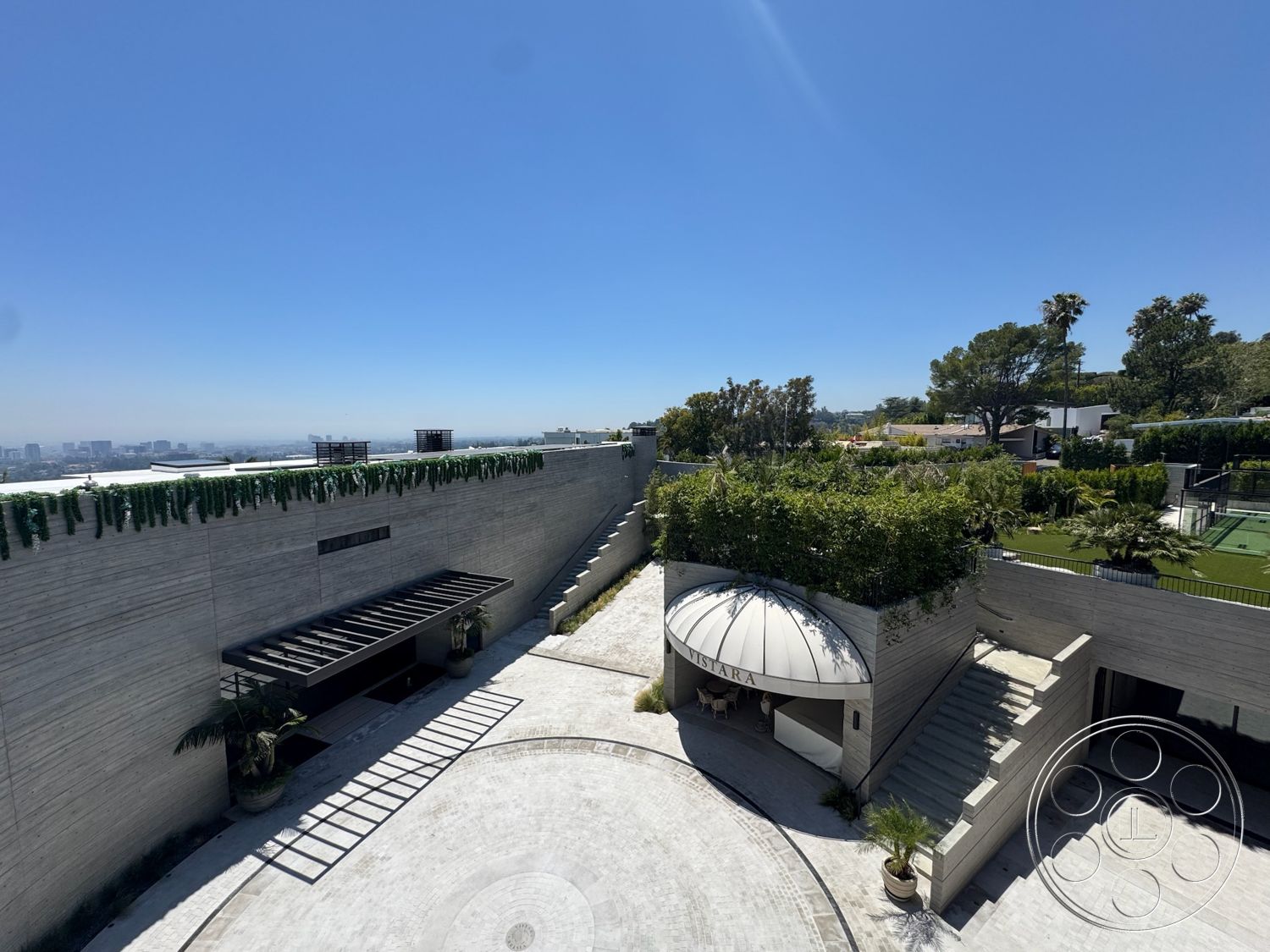 Star Villa - exterior, concrete walls, curved driveway, natural stone pathway, terraced landscaping, flat roof design, landscaped garden area, glass partition walls, outdoor patio area, vaulted entryway ceiling, exposed concrete surfaces, overhead metal trellis, circular stone patio flooring