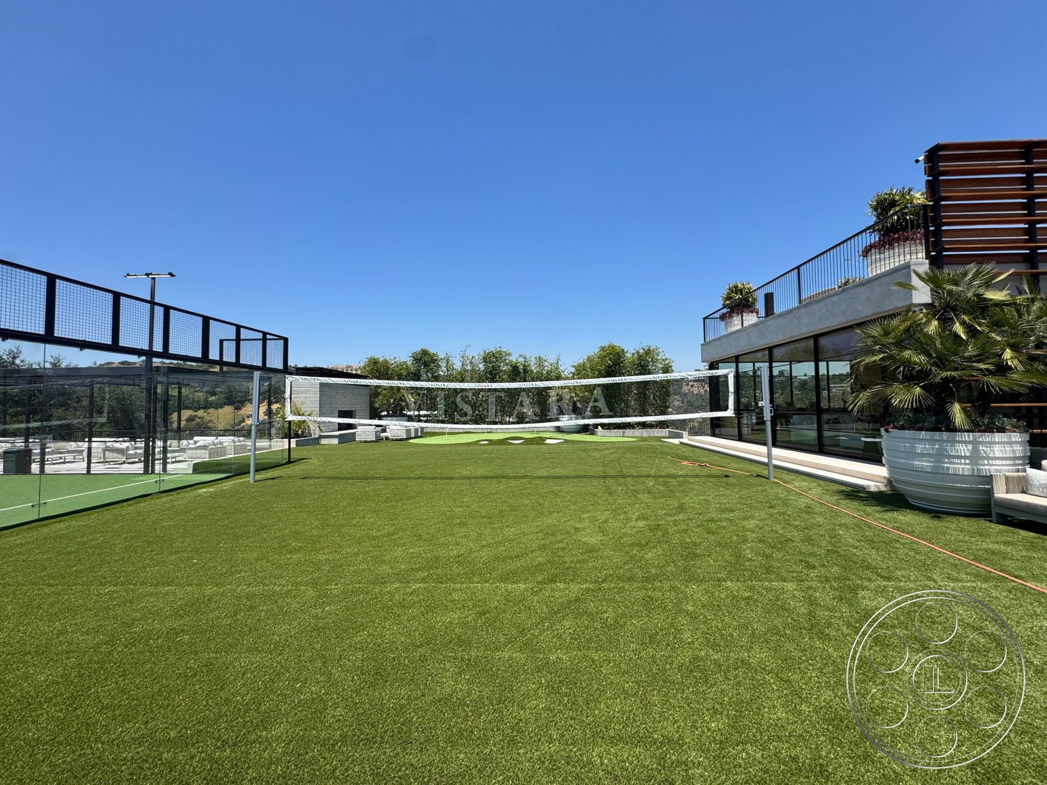 Star Villa - exterior, artificial turf lawn, concrete patio flooring, floor-to-ceiling glass windows, modern architectural design, urban rooftop setting, panoramic hillside view, glass volleyball court enclosure, metal railing with wooden slats, green planting areas