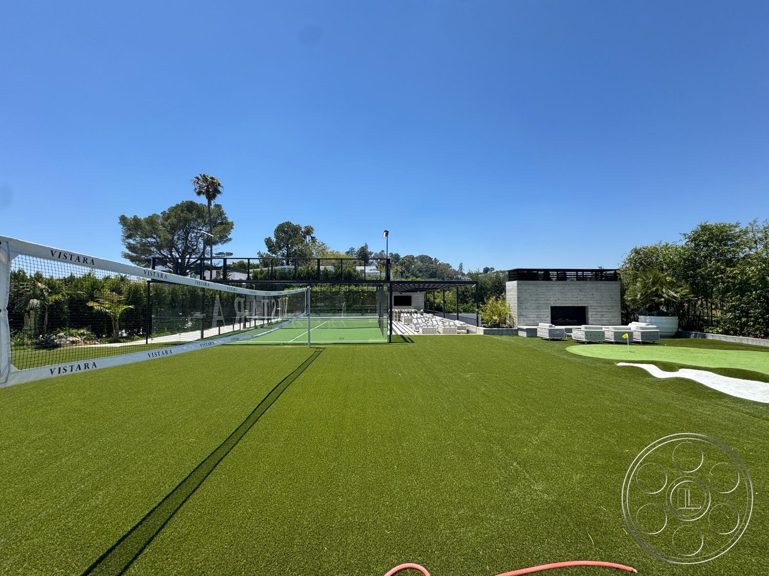 Star Villa - poolside lounge area, sleek outdoor furniture, steel pergola structure, modern outdoor living space, clear blue sky setting, planted landscaping features, concrete outdoor seating area, artificial turf tennis court, white stone exterior walls, sunny backyard environment