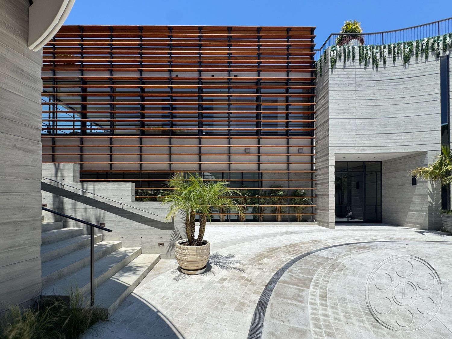 Star Villa - exterior, paver driveway, concrete walls, floor-to-ceiling windows, horizontal wood siding, contemporary architectural style, steel stair railings, wood slat feature wall, landscaped garden with palm trees, wide entryway, curved stone steps