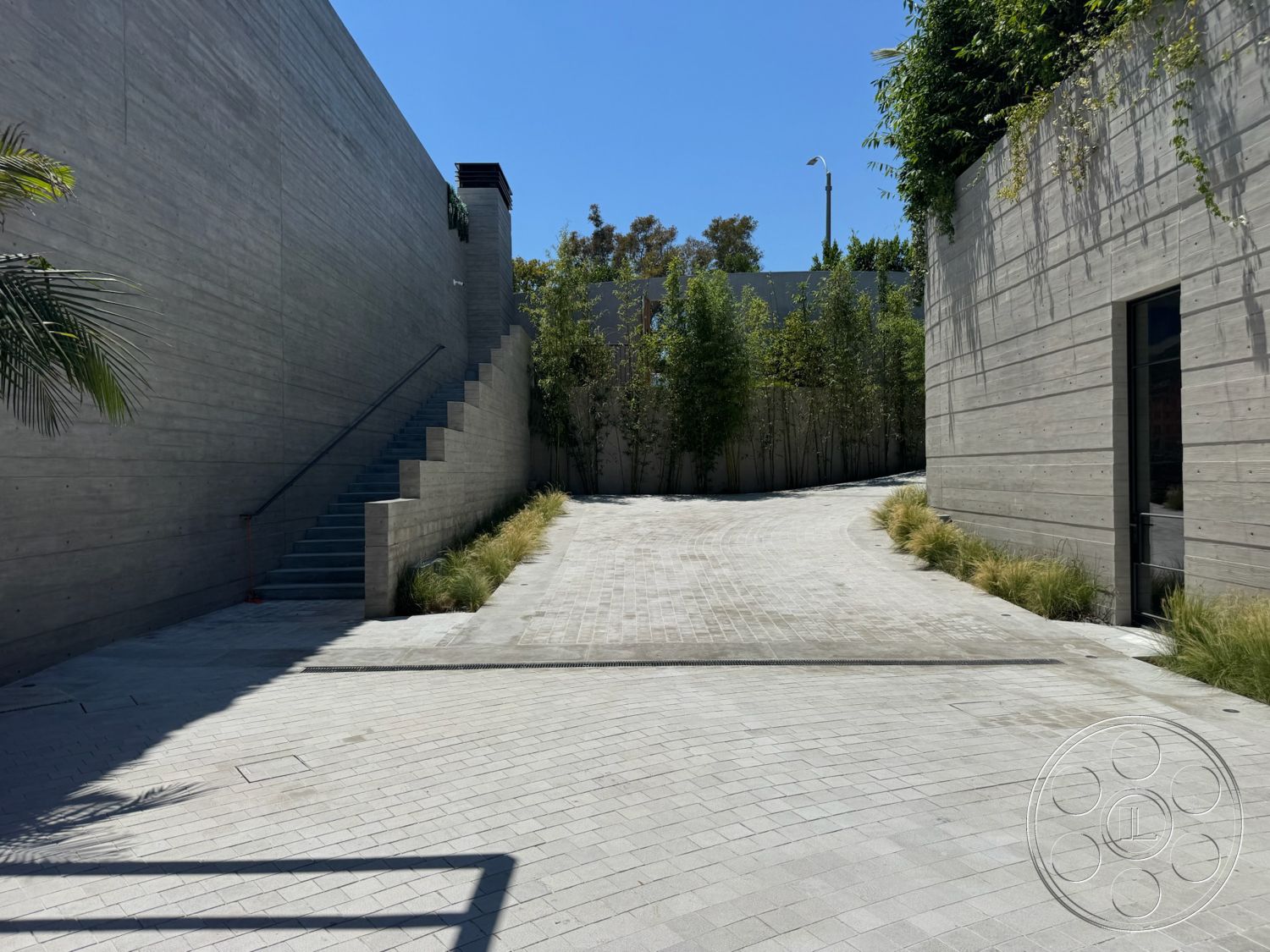 Star Villa - exterior, modern architectural style, open outdoor space, curved driveway, landscaped garden area, minimalist outdoor design, floor-to-ceiling glass doors, stamped concrete driveway, concrete block construction, raised concrete steps, concrete retaining walls, bamboo plants lining pathway