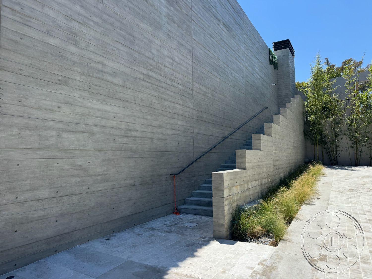 Star Villa - exposed concrete walls, landscaped garden beds, modern architectural design, steel stair railings, textured concrete patio flooring, interior/exterior transition space, linear planting beds, concrete stair steps