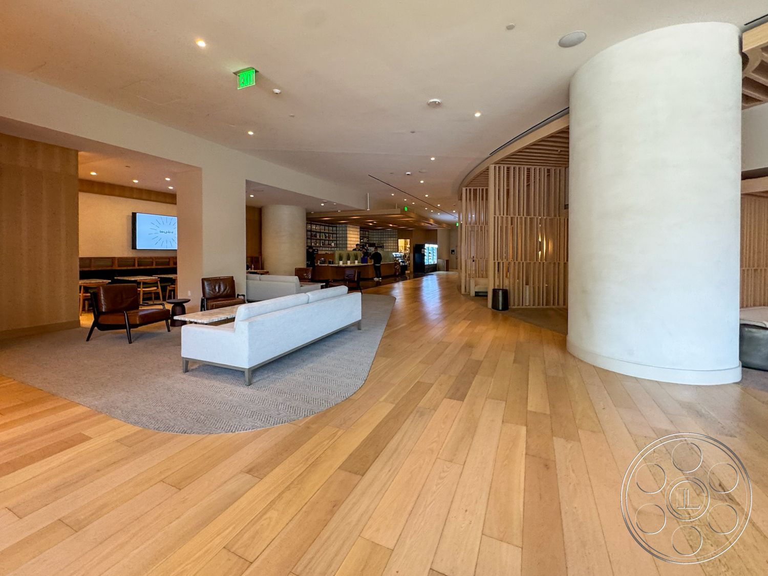 Office 123 - neutral color palette, textured area rug, light hardwood flooring, open floor plan, lounge area, arched entrance, upholstered armchairs, ambient lighting fixtures, modern minimalist sofa, plastered wall finishes, curved wall structure, wood slat partition, reception desk area