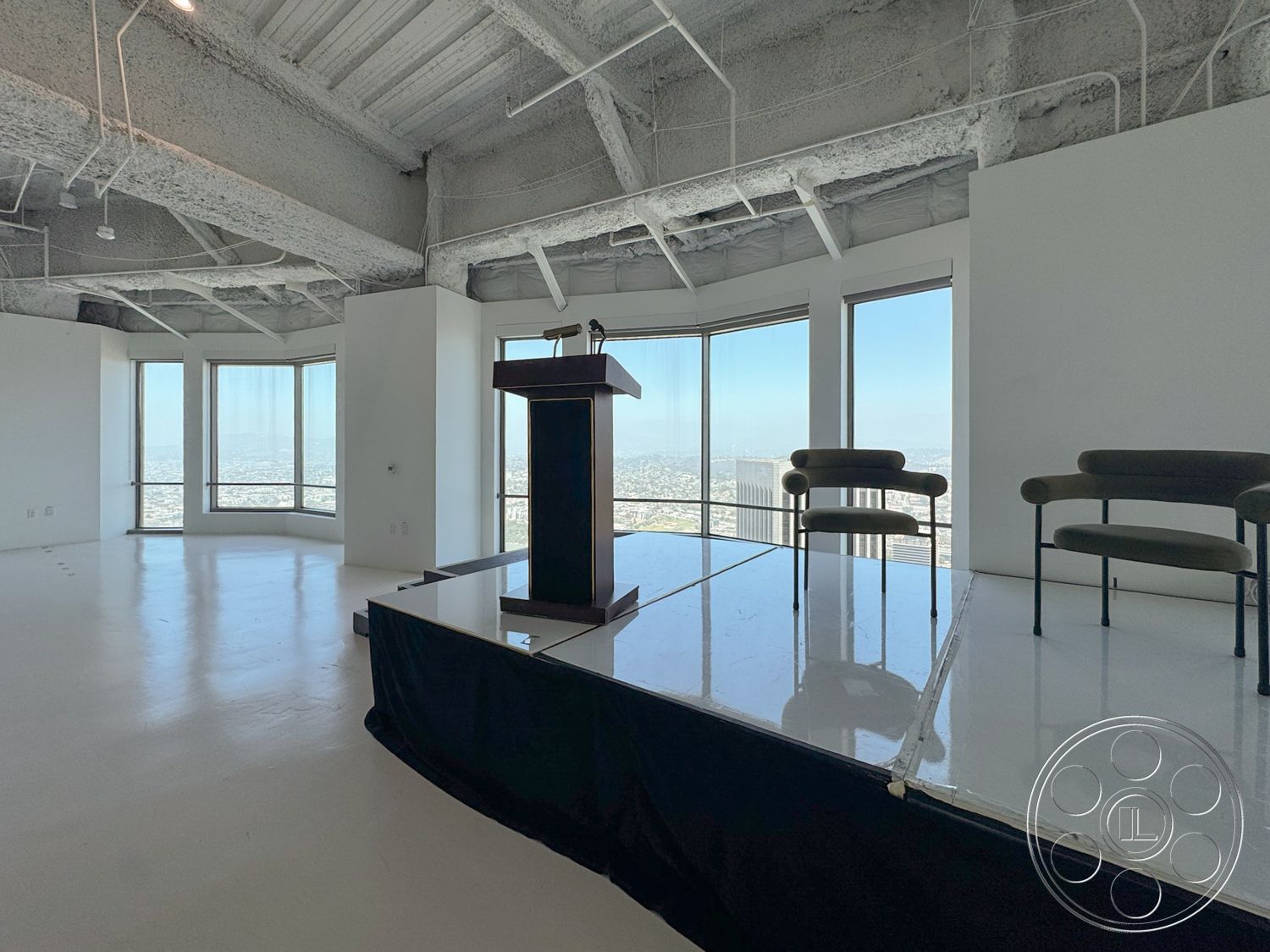 Office 123 - polished concrete flooring, floor-to-ceiling windows, city skyline view, exposed concrete ceiling, white painted walls, curved seating arrangement, modern podium