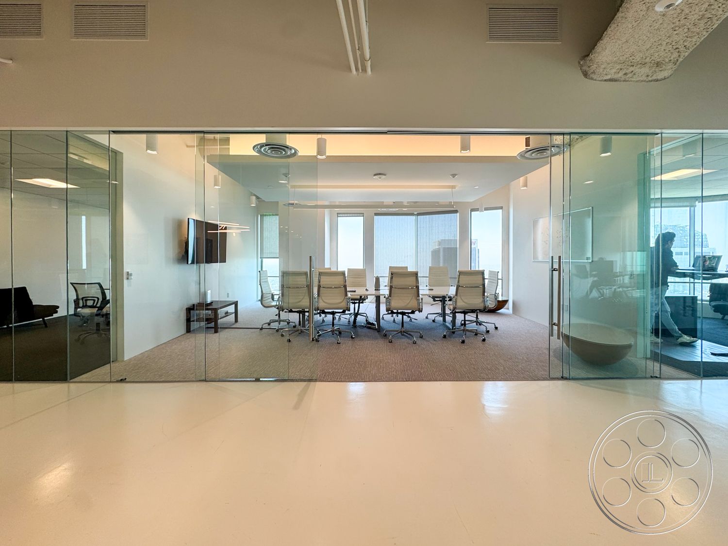 Office 123 - neutral color palette, minimalist design, floor-to-ceiling windows, suspended ceiling lights, white painted walls, carpet office flooring, modern conference table, glass conference room walls, wall-mounted flat-screen television, high-back office chairs, exposed concrete ceiling beam