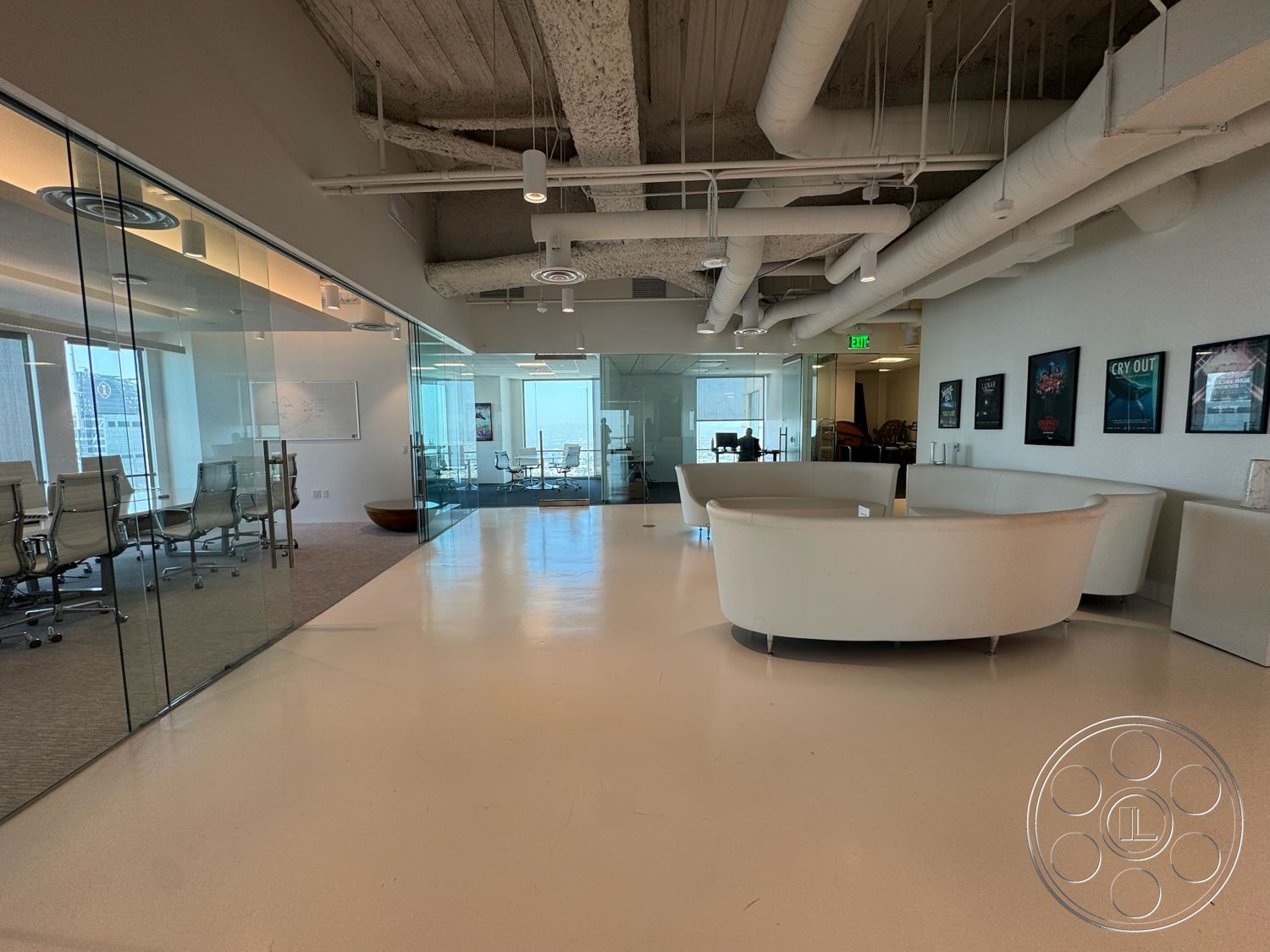 Office 123 - polished concrete flooring, vaulted ceiling, acoustic ceiling tiles, glass partition walls, minimalist design aesthetic, exposed ductwork ceiling, modern office furniture, white curved seating area, brightly lit workspaces