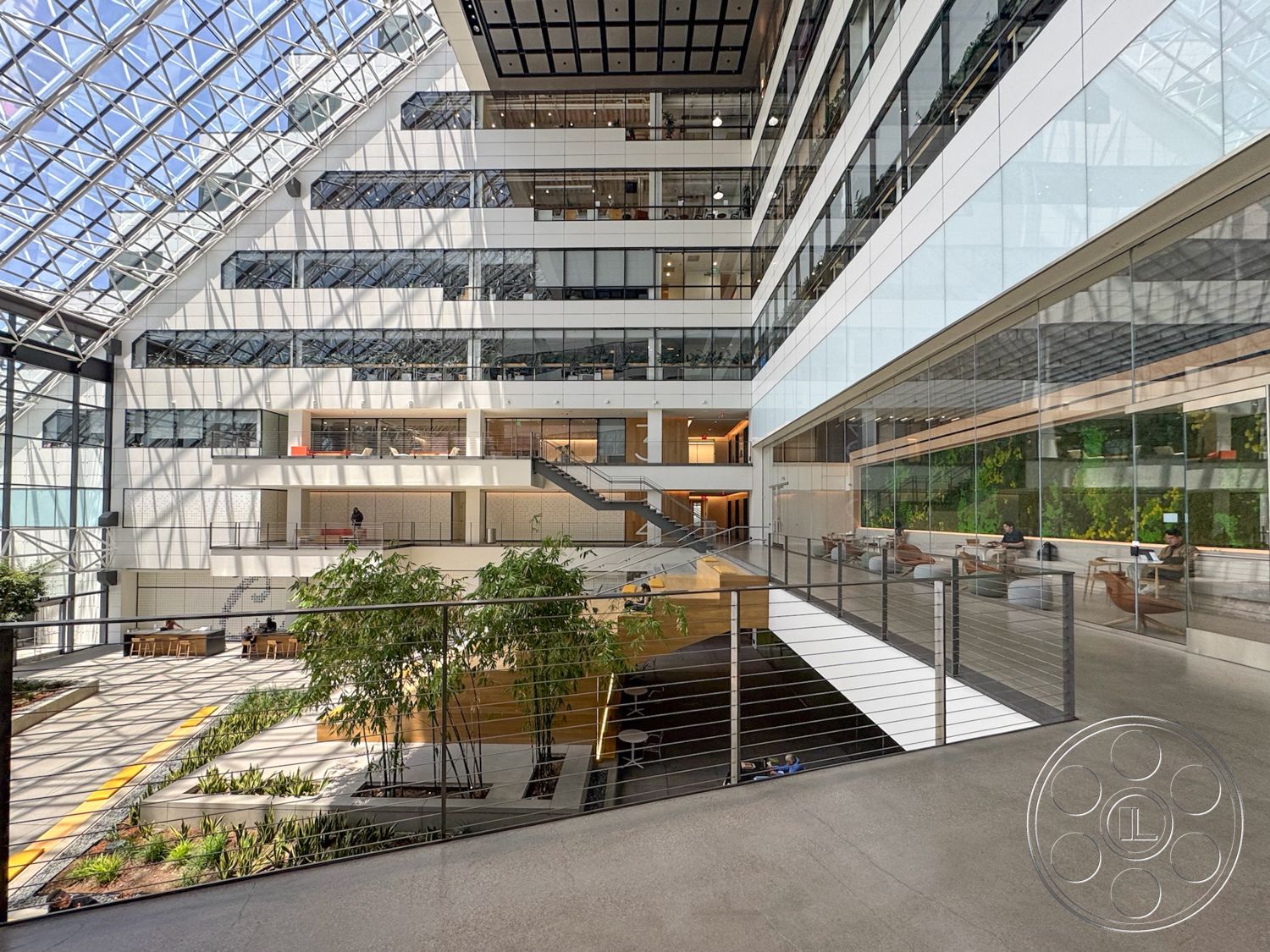 The Atrium - natural light, exterior, modern architecture, concrete floors, glass facade, geometric shapes, suspended ceiling, multiple levels, large floor-to-ceiling windows, wood accent elements, integrated greenery, urban office environment, steel stair railings, open atrium, landscaped indoor garden, central staircase