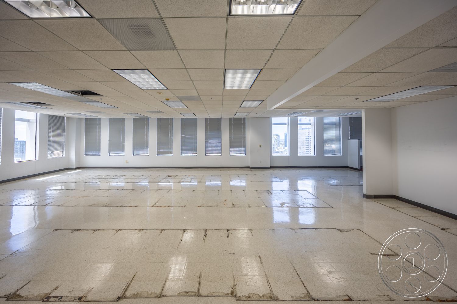 Rooftop 53 - minimalist design, polished concrete floors, urban city view, drop ceiling tiles, fluorescent lighting fixtures, large windows with blinds, office space layout, exposed subfloor