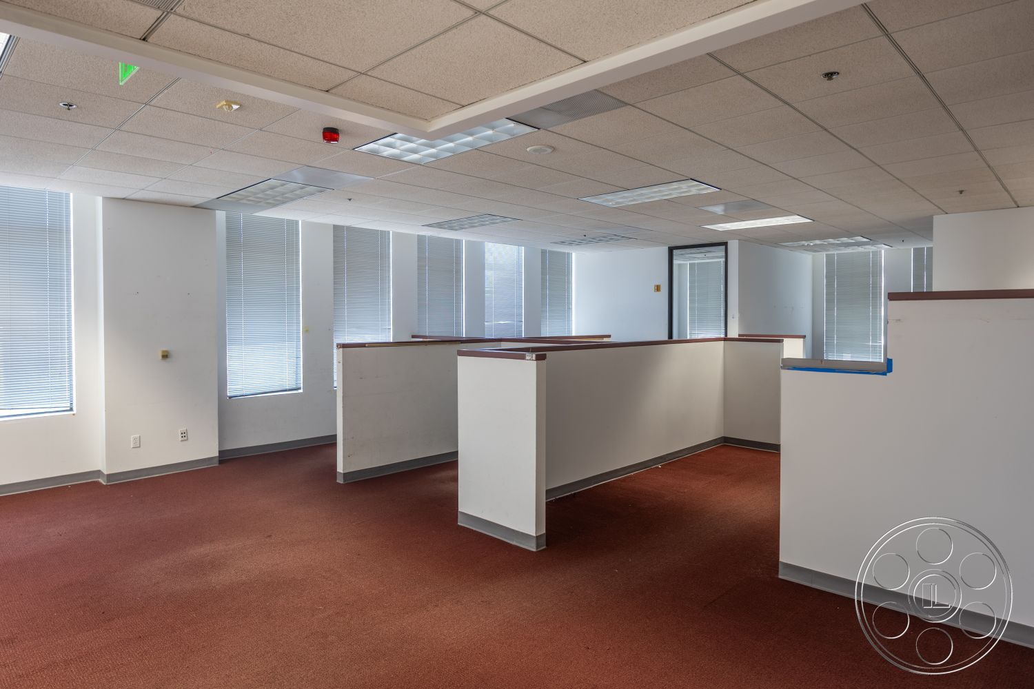 Rooftop 53 - floor-to-ceiling windows, carpet flooring, white painted walls, interior office space, drop ceiling tiles, rectangular office layout, fluorescent ceiling lights, internal partition walls, blinds on windows