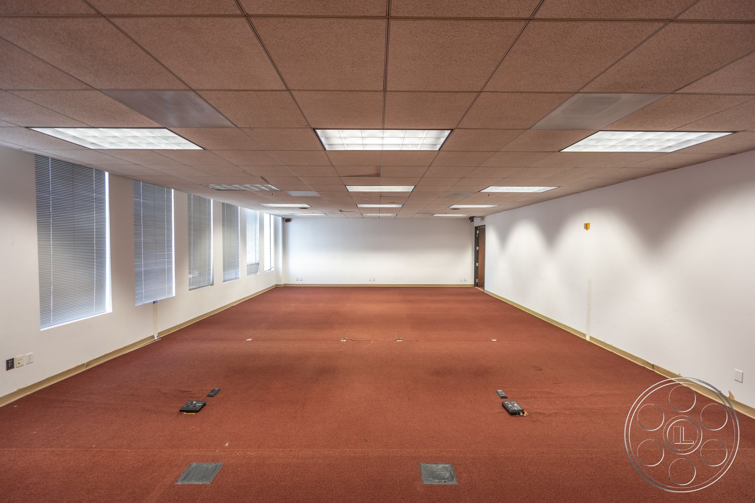 Rooftop 53 - acoustic ceiling tiles, white painted walls, carpet office flooring, rectangular office layout, flush-mounted ceiling lights, window treatments with blinds, exterior door access