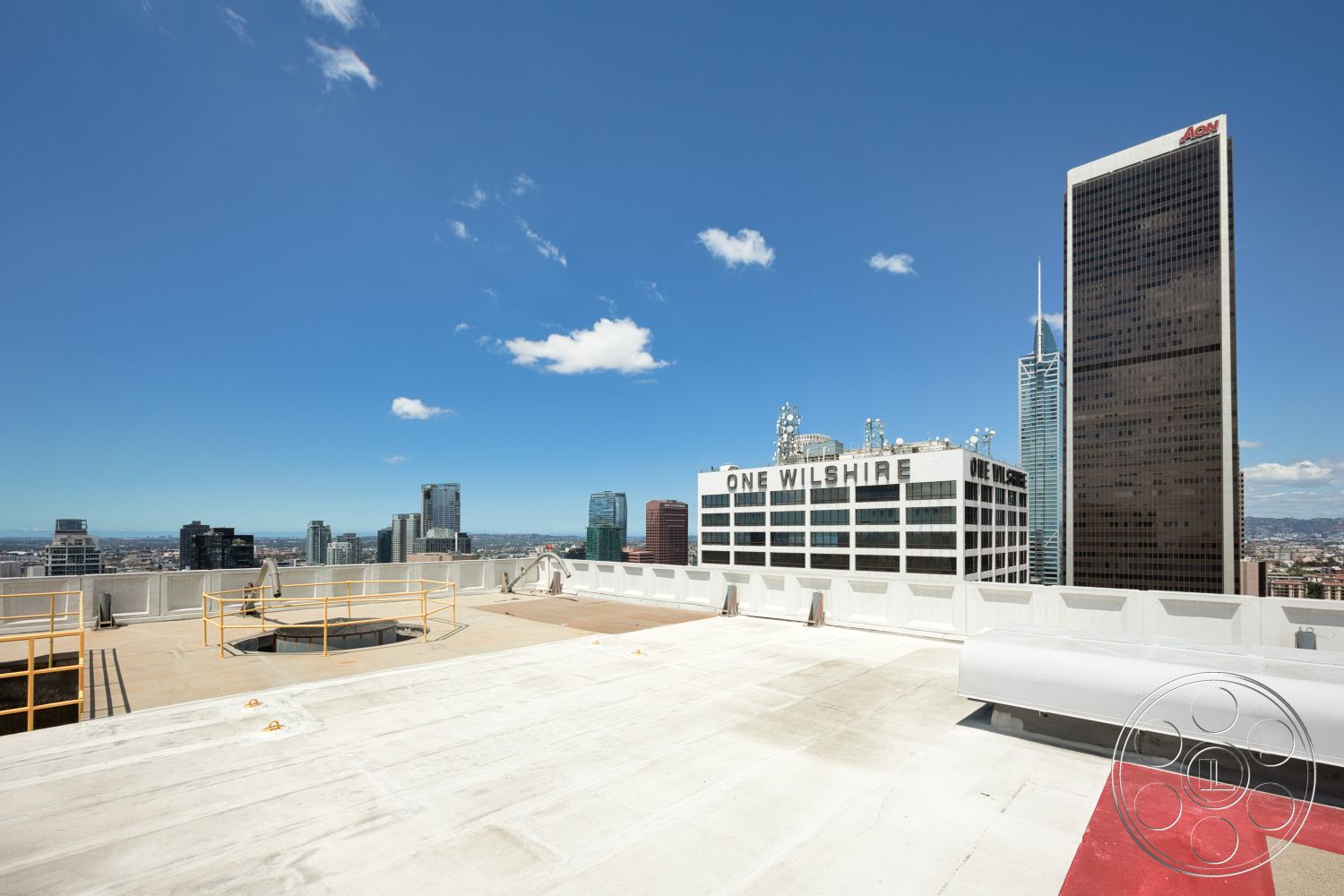 Rooftop 53 - exterior, urban environment, city skyline view, clear blue sky, commercial buildings, metal safety railing, industrial architectural style, panoramic cityscape, flat rooftop surface, concrete rooftop