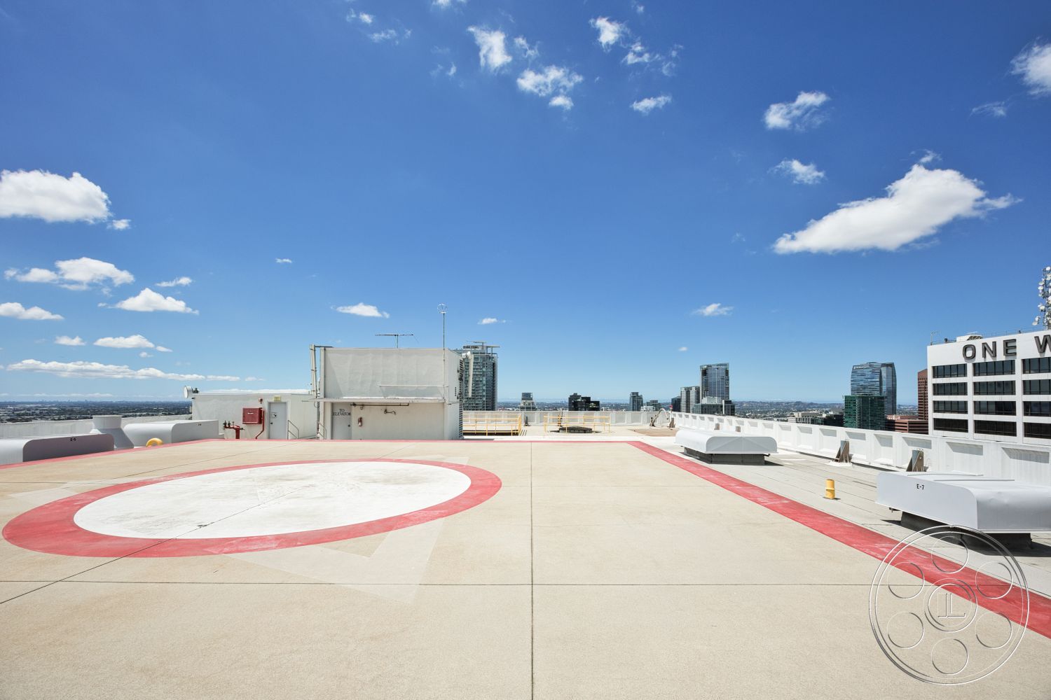 Rooftop 53 - exterior, urban skyline view, flat roof design, surrounding urban architecture, concrete rooftop, blue sky with clouds, helipad with red circular markings