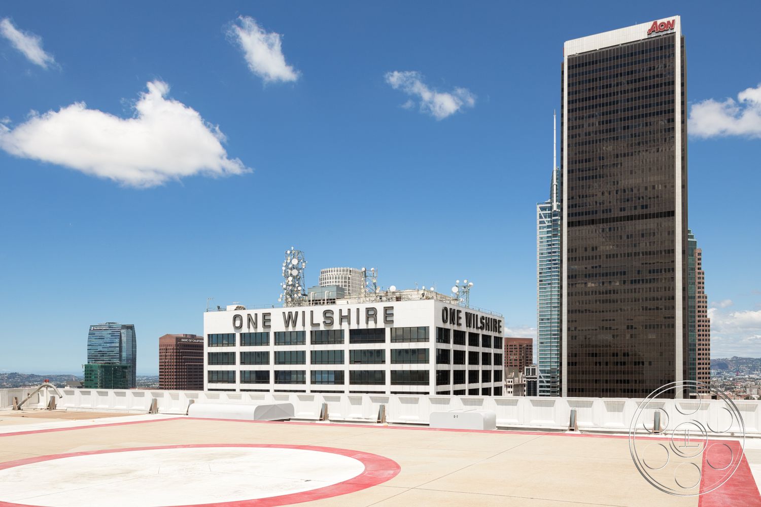Rooftop 53 - modern architecture, commercial building, urban skyline view, flat roof design, city environment, high-rise structures, glass facade buildings, exterior signage, open sky setting, concrete rooftop helipad, brushed metal accents, dropped ceilings, interior rooftop space