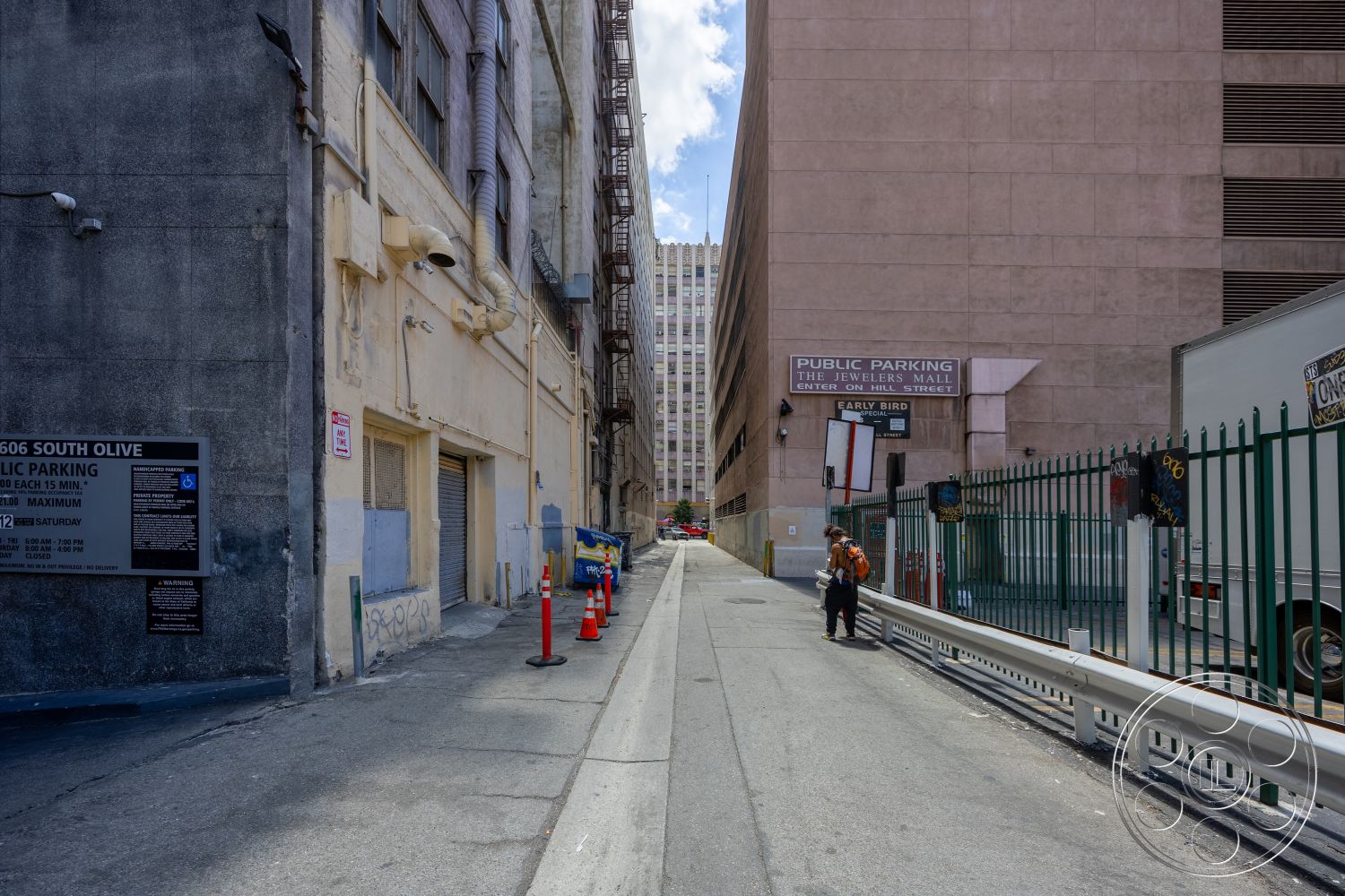 Rooftop 53 - exterior, commercial building, urban environment, asphalt road surface, metal security fence, signage on building facade, brick building walls, concrete alleyway paving, painted concrete wall, steel fire escape, parking lot signage, public parking structure, downtown location