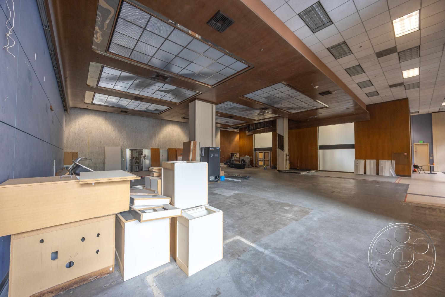 Rooftop 53 - concrete flooring, commercial space, wood panel accent wall, drop ceiling tiles, flat ceiling design, industrial-style interior, exposed wood ceiling panels, neutral color palette walls, large, open floor plan, interior renovation space, bulk storage area, temporary fixtures and furnishings