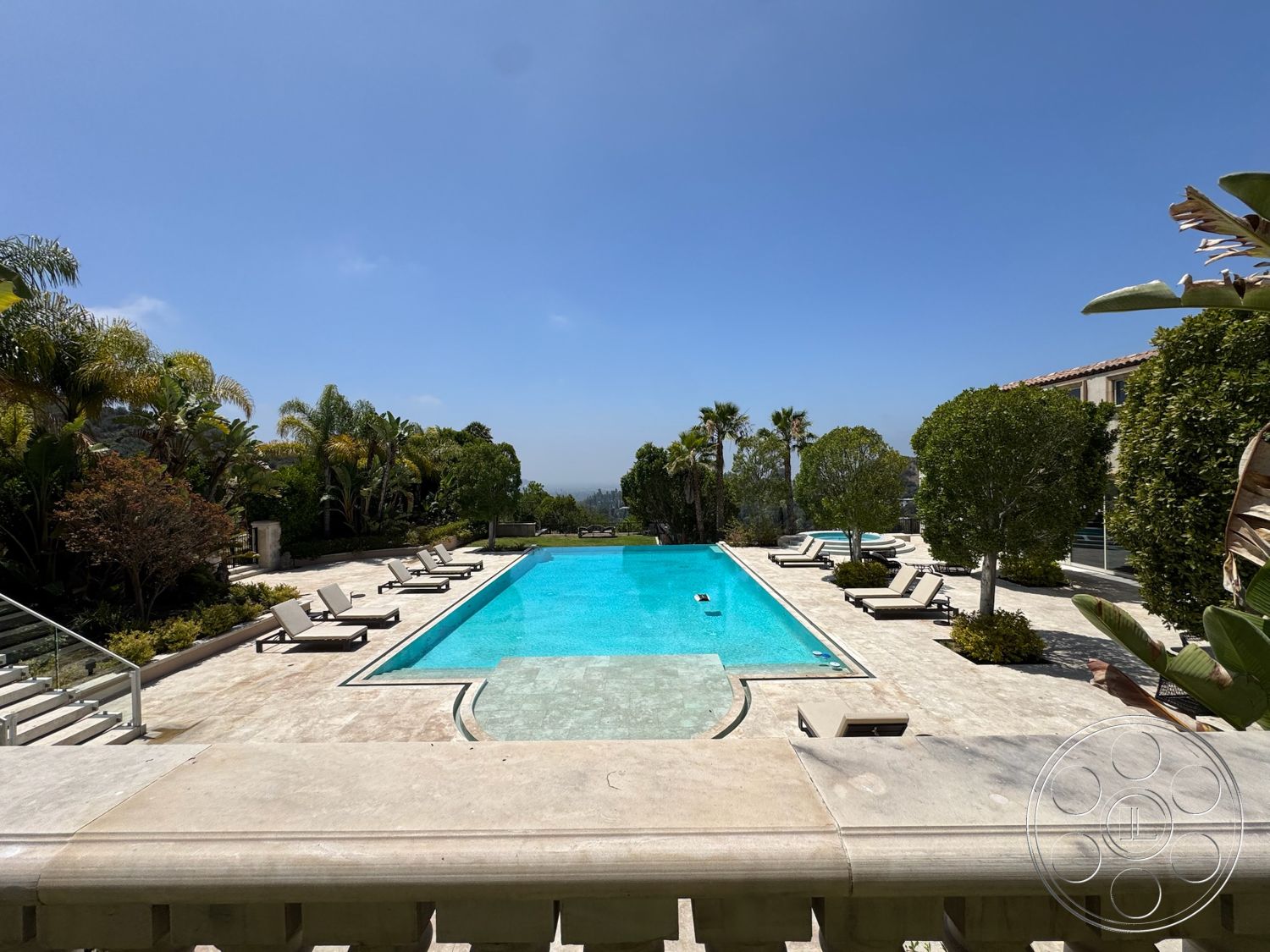 Beverly Compound - exterior, rectangular swimming pool, clear blue sky, sun loungers, luxurious outdoor space, tropical palm trees, concrete patio flooring, concrete pool border, marble pool deck, landscaped garden areas