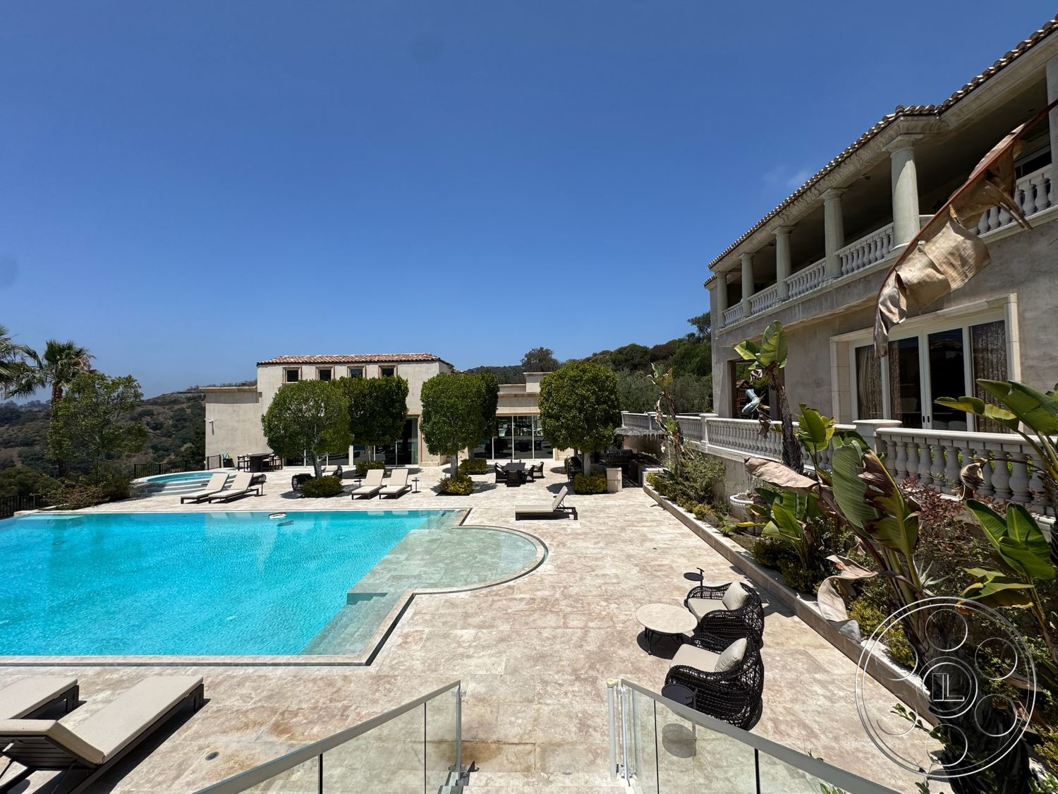 Beverly Compound - exterior, flat roof, lush greenery, outdoor seating area, mountain view, sun loungers, textured plaster walls, rectangular pool, stone pool deck, landscaped garden area, contemporary home design, marble patio flooring, balcony with stone railing