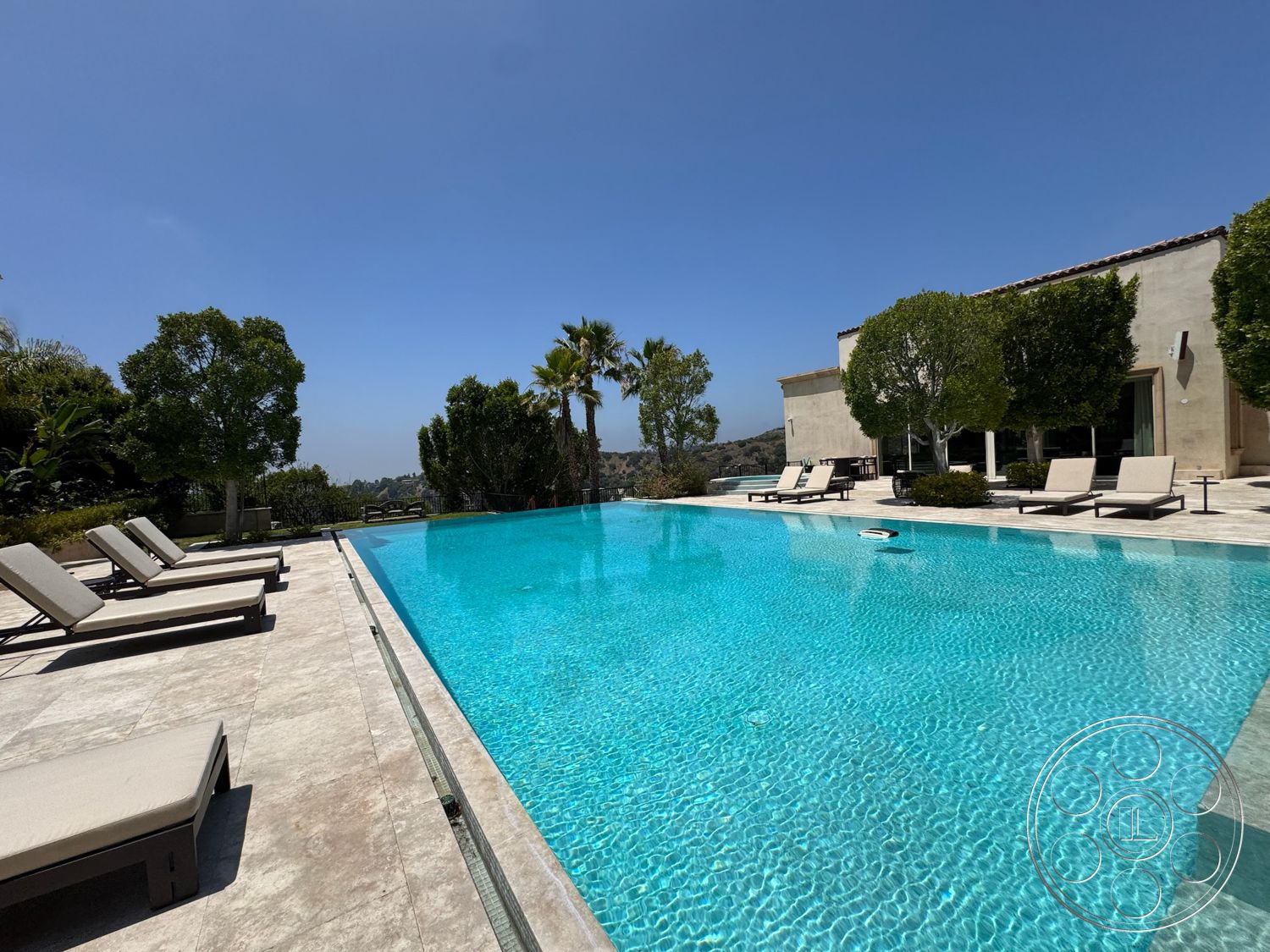 Beverly Compound - floor-to-ceiling windows, lush landscaping, textured wall finishes, rectangular pool, paved pool deck, stone patio flooring, modern exterior architecture, surrounding mountain view, luxury lounge chairs