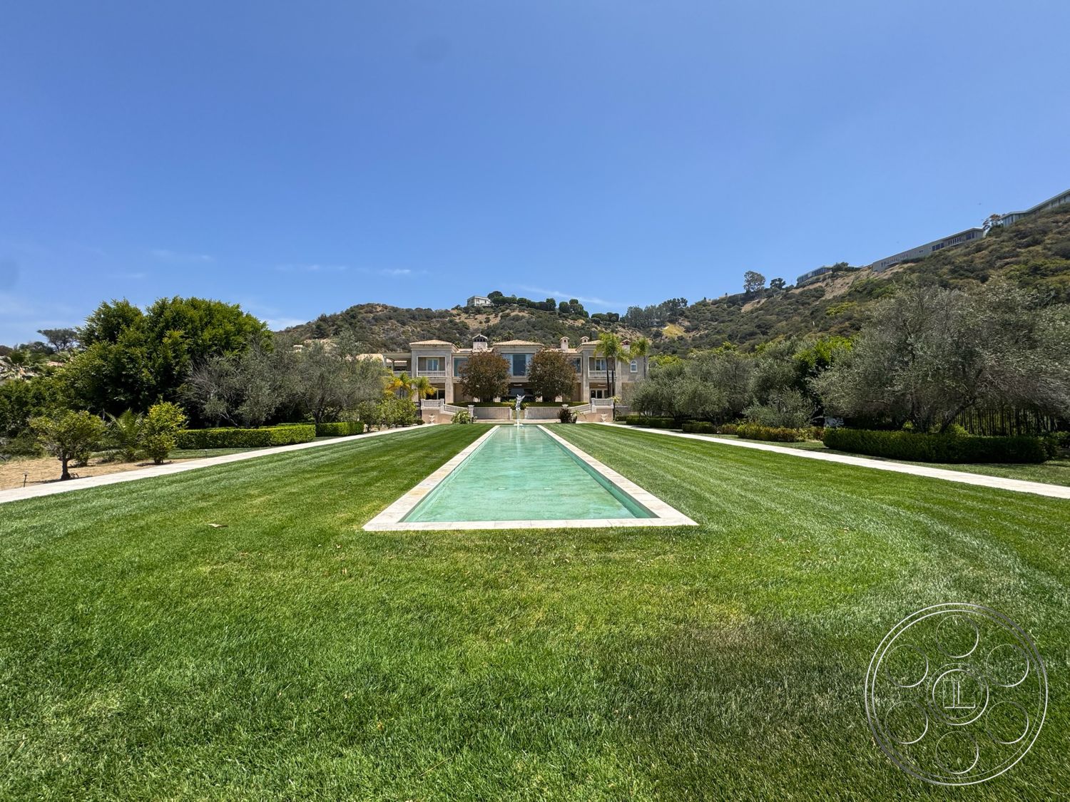 Beverly Compound - exterior, stone pathway, balcony with railing, manicured lawn, hillside setting, rectangular pool, Mediterranean architectural style, two-story home, landscaped garden beds, concrete pool edge