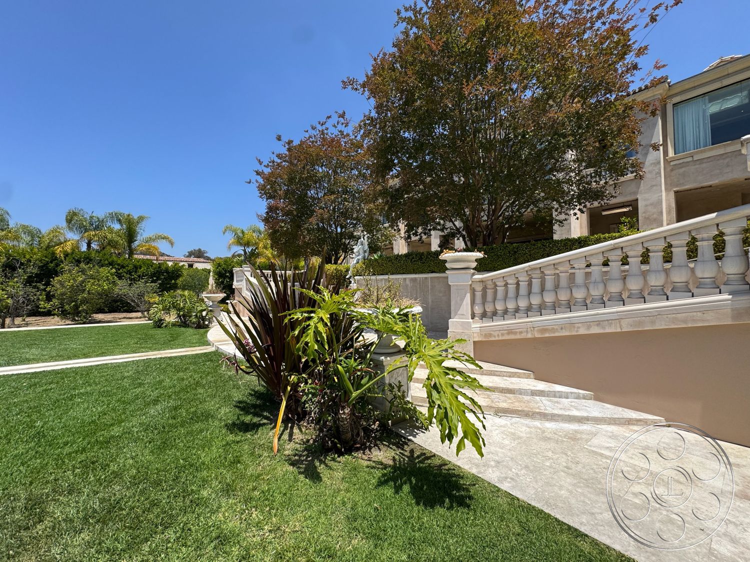 Beverly Compound - exterior, lush greenery, textured wall, tropical plants, paved walkway, curved staircase, landscaped garden area, granite patio flooring, concrete garden walls, marble steps, detailed balustrade railing, upscale residential setting