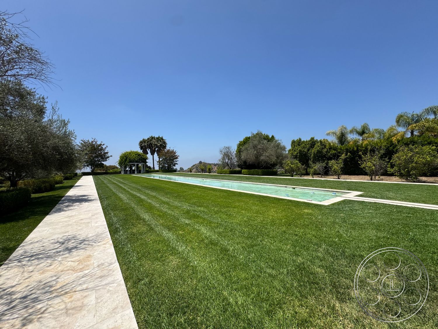 Beverly Compound - exterior, green grass, palm trees, spa-like atmosphere, stone walkway, manicured lawn, blue sky, tropical landscaping, rectangular pool, outdoor gazebo, hedge borders