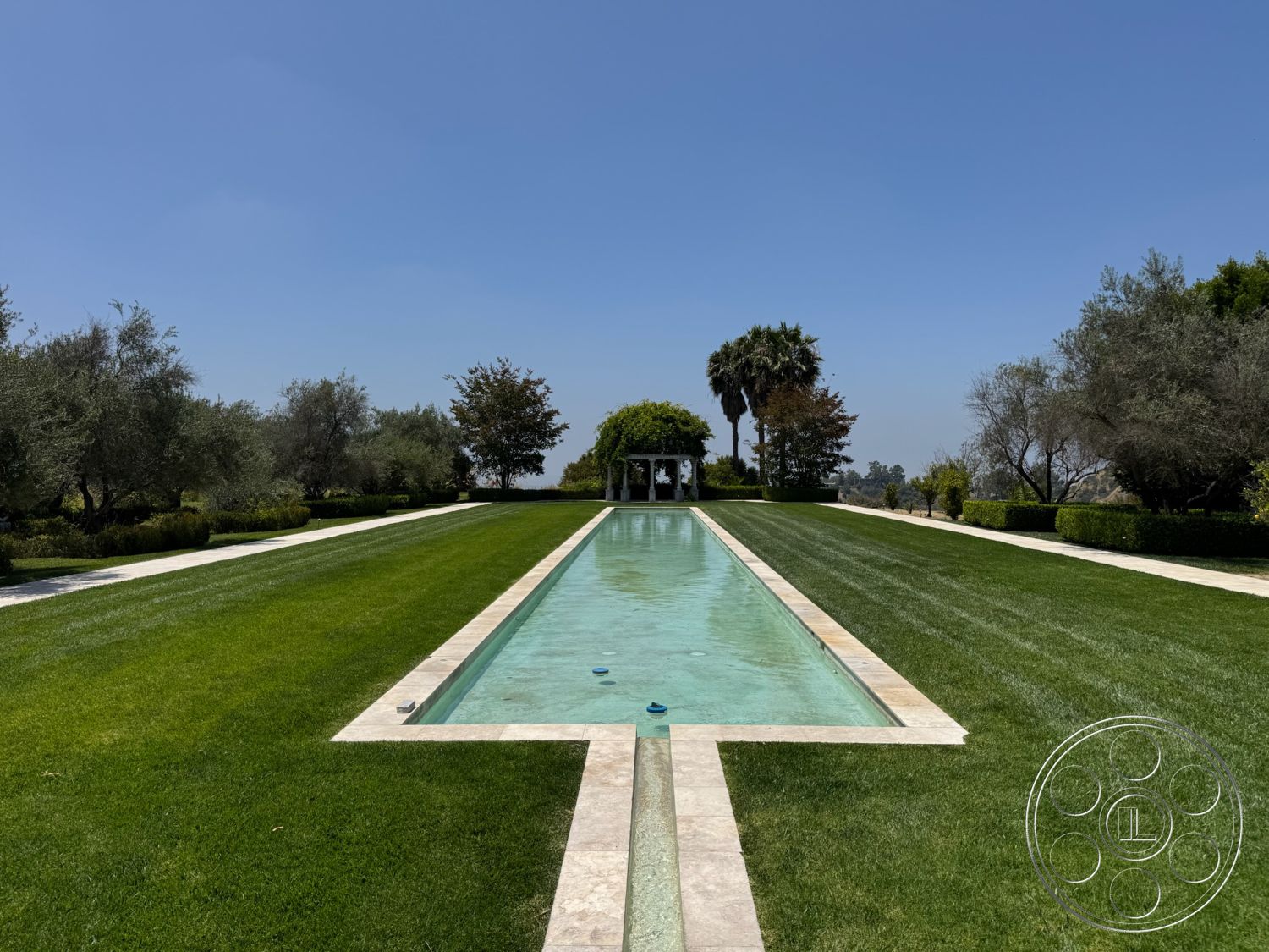 Beverly Compound - exterior, clear sky, rectangular swimming pool, manicured lawn, garden setting, hedge landscaping, marble pool border, stone patio pathway, palms and trees